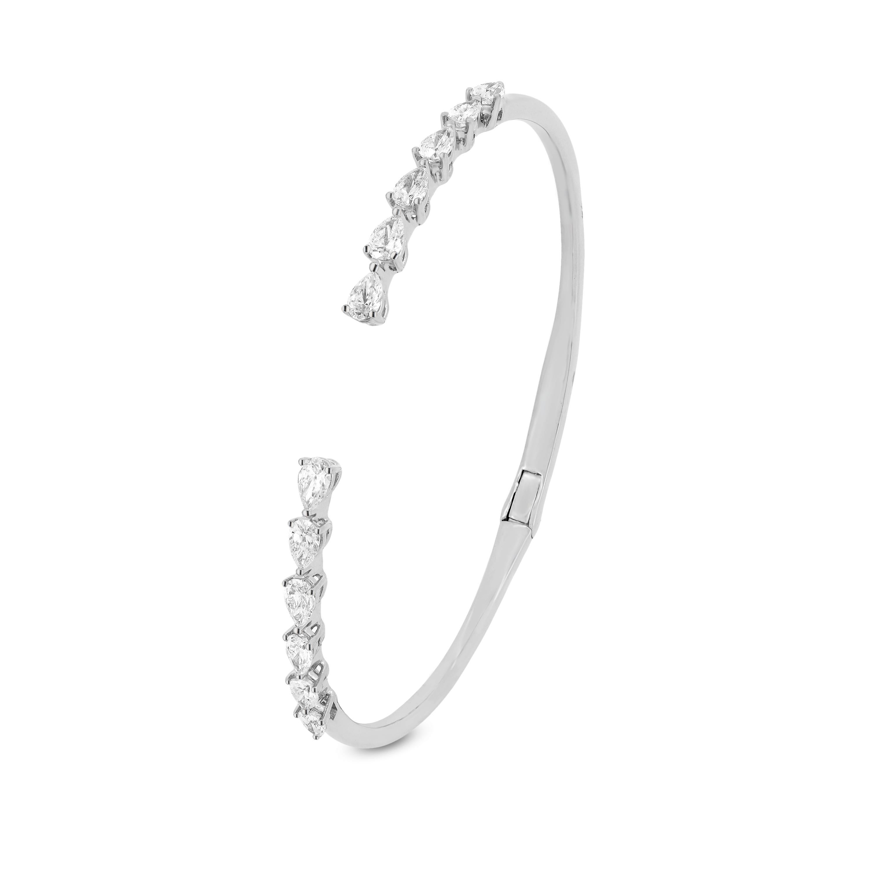 This cuff diamond bangle bracelet has 12 pear full cut White Diamonds crafted on an 18K white gold band. This minimal and sleek prong set diamond jewelry has 1.70 cwt of shining diamonds that adds an oomph factor to your wrist. The diamonds are SI1