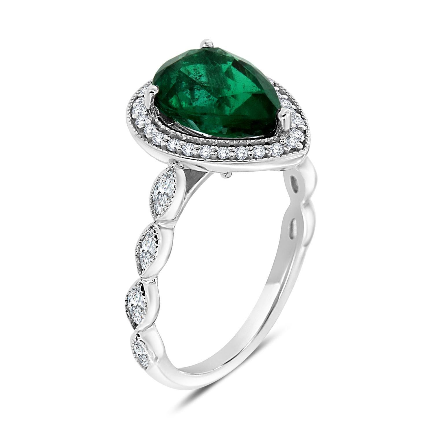 Wear Art every day! This delicate ring features a 1.95 Carat Pear- Shape vibrant Green Natural Emerald from Zambia in an excellent luster encircled by a halo of brilliant round diamonds with a touch of a milgrain design. From each side of the ring's