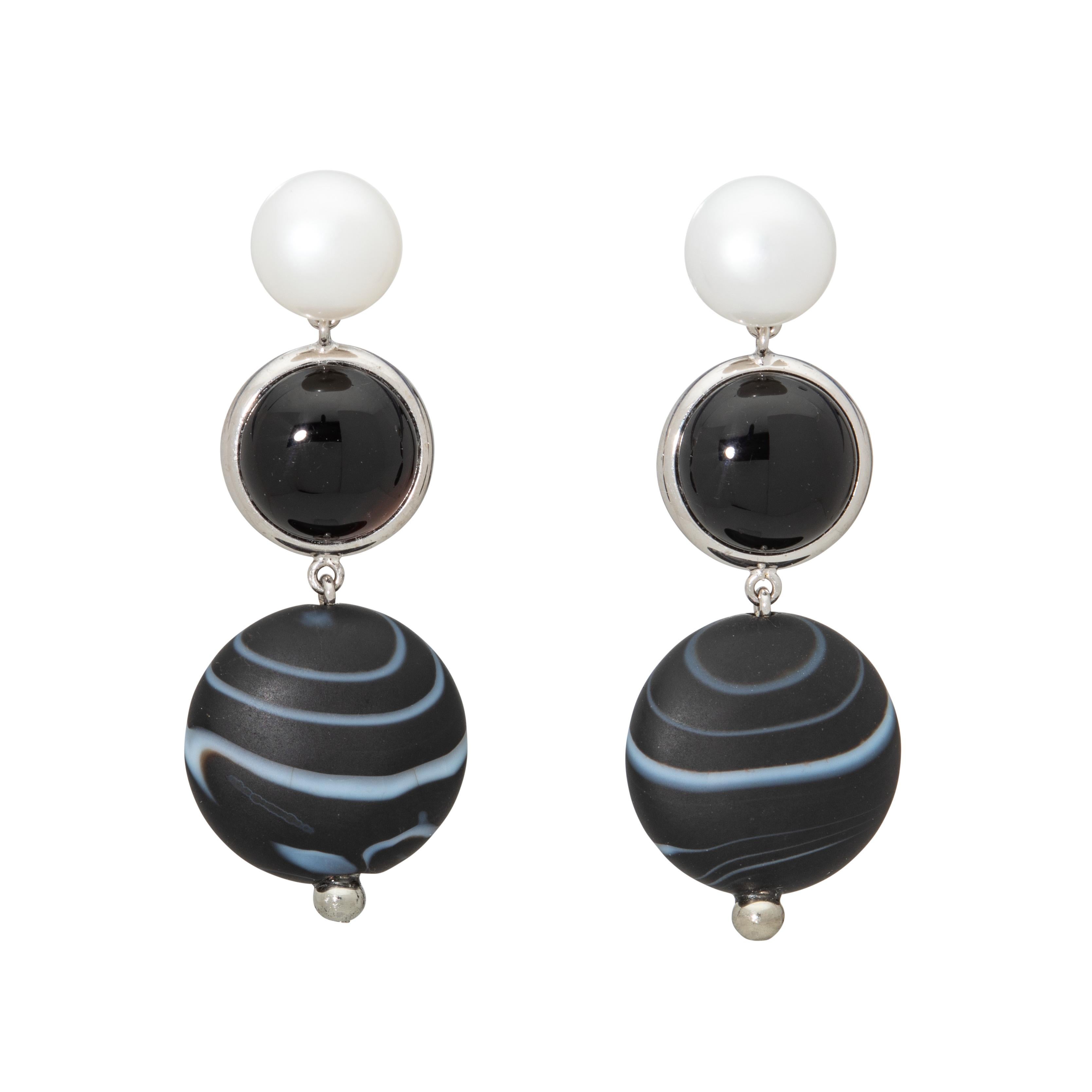 Looking at these earrings will take you away to the farthest reaches of the Cosmos, where darkness and light are juxtaposed in beautiful synchronicity. The shiny white pearl that adorns the top, followed by the deep, dark onyx, giving way to the