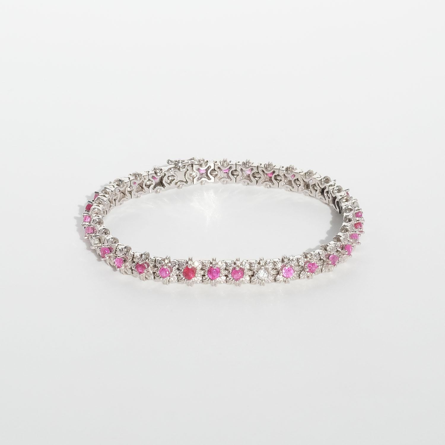 This 18 karat white gold bracelet is adorned with pink and white sapphires which are surrounded by flower settings. The bracelet closes easily with a box clasp and it has a safety catch.

The handcraft of this bracelet is amazing. It may be