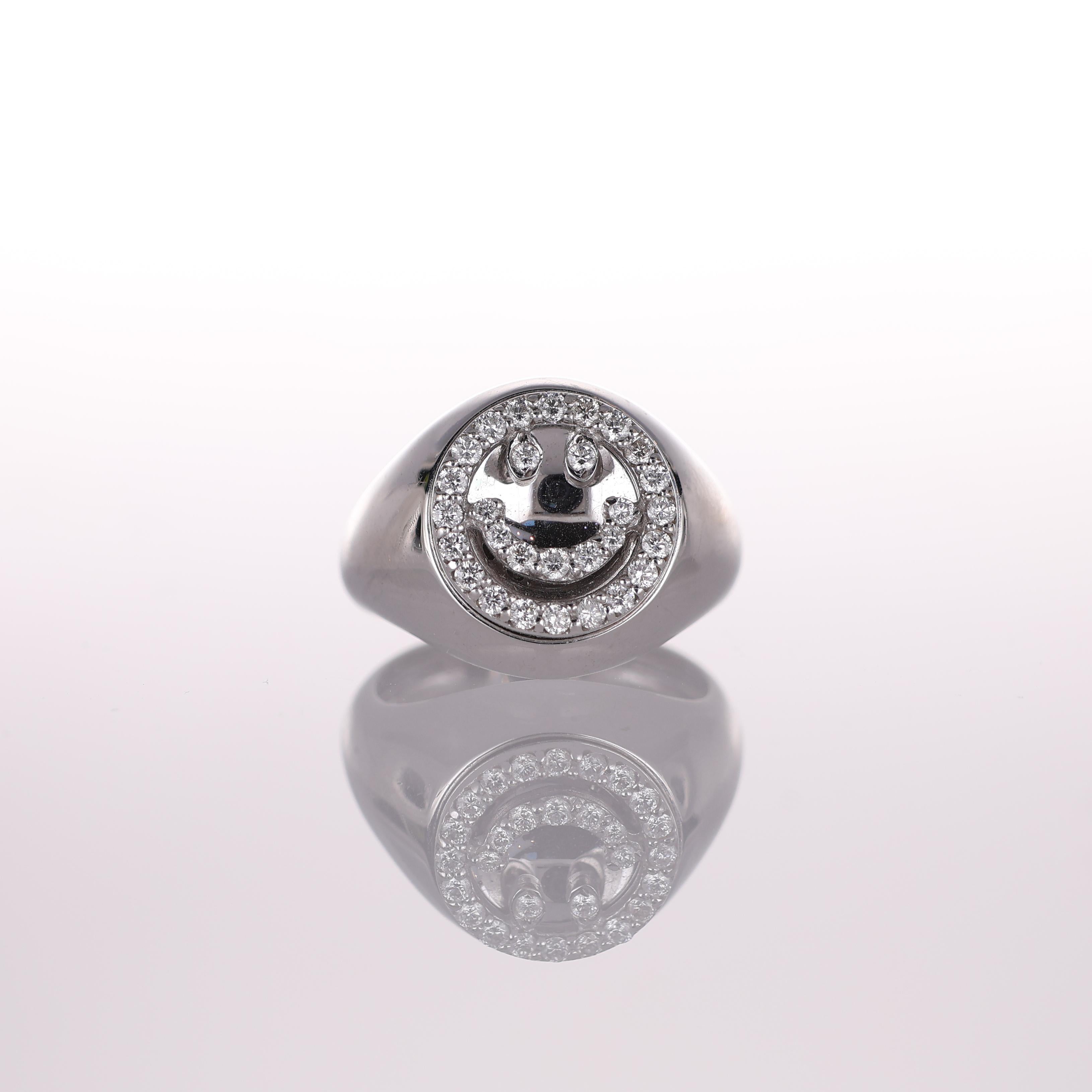 A playful yet refined pinky ring crafted in 18K white gold, featuring a smiley face motif adorned with 0.31 carats of brilliant-cut diamonds. The polished gold surface enhances the sparkle of the diamonds, creating a modern and eye-catching design.