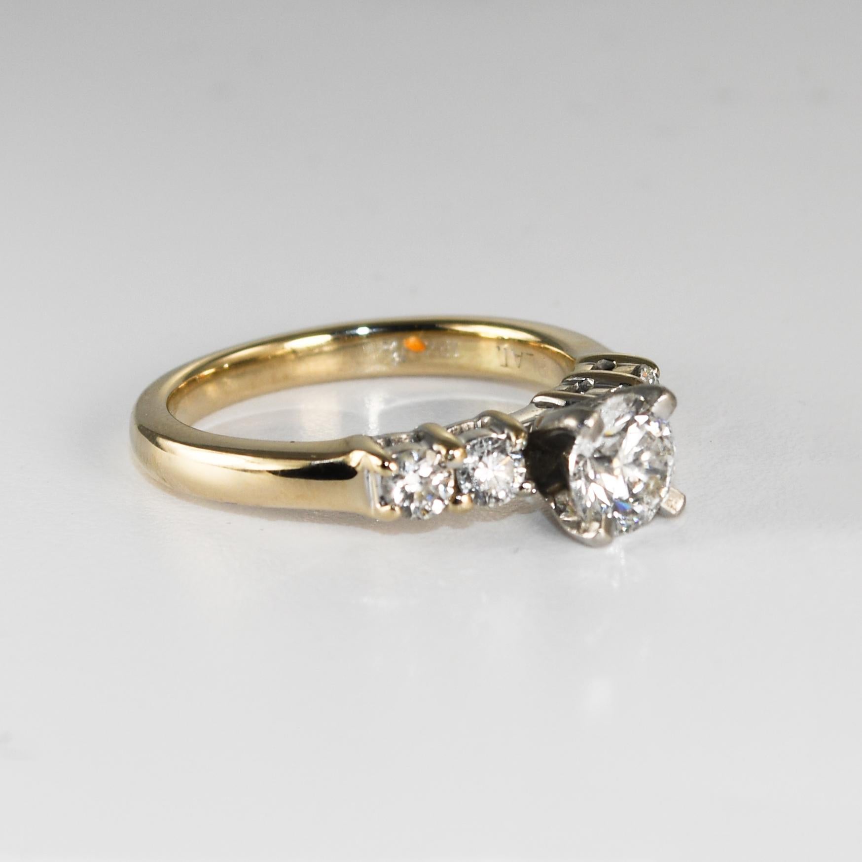 18k yellow gold, platinum, and diamond engagement ring.
Stamped 18k, Plat, and weighs 4.9 grams gross weight.
The center diamond is set in a platinum head.
The center diamond is a .70 carat round brilliant cut, E color, Vs1 clarity, Very good cut