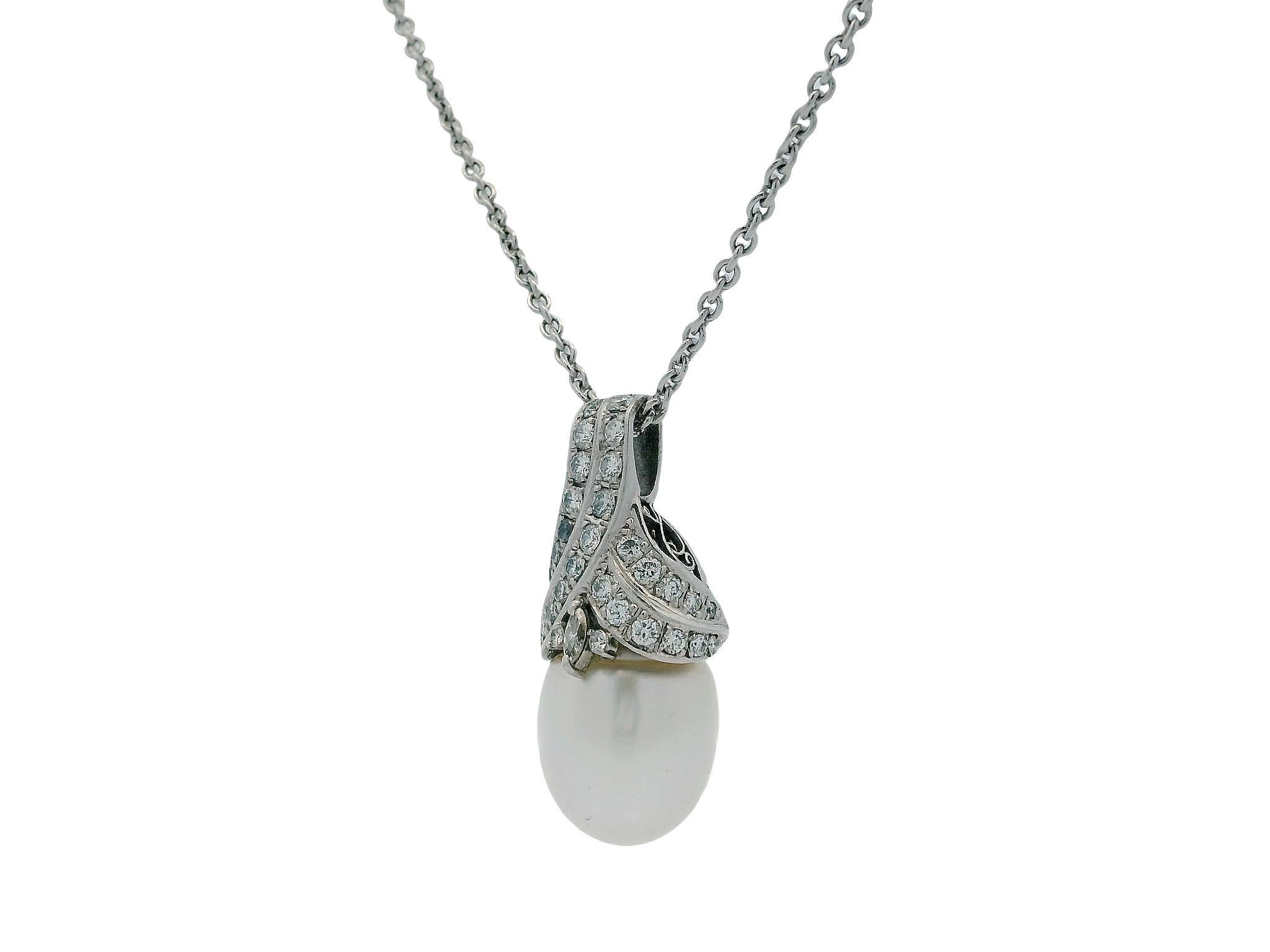 Questa elegante collana combina oro bianco 18 carati e platino in un design straordinario. Al centro, una perla lucente è in mostra, graziosamente sospesa da una splendida montatura ricurva ornata da diamanti scintillanti. L'intricata lavorazione