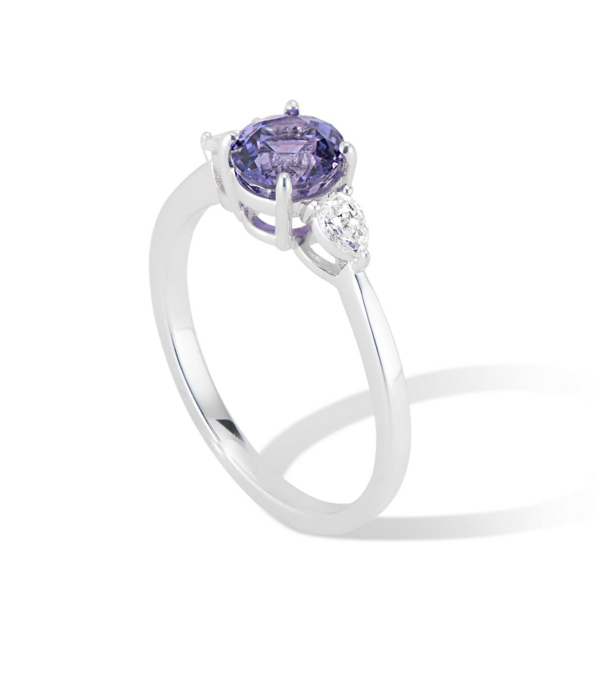 A stunning unheated 1.11 carat unheated Purple Madagascar Sapphire center stone flanked by two scintillating Pear Shaped diamonds in a low profile 18k white gold setting. 
Three stone Engagement rings are enjoying a huge moment of popularity
