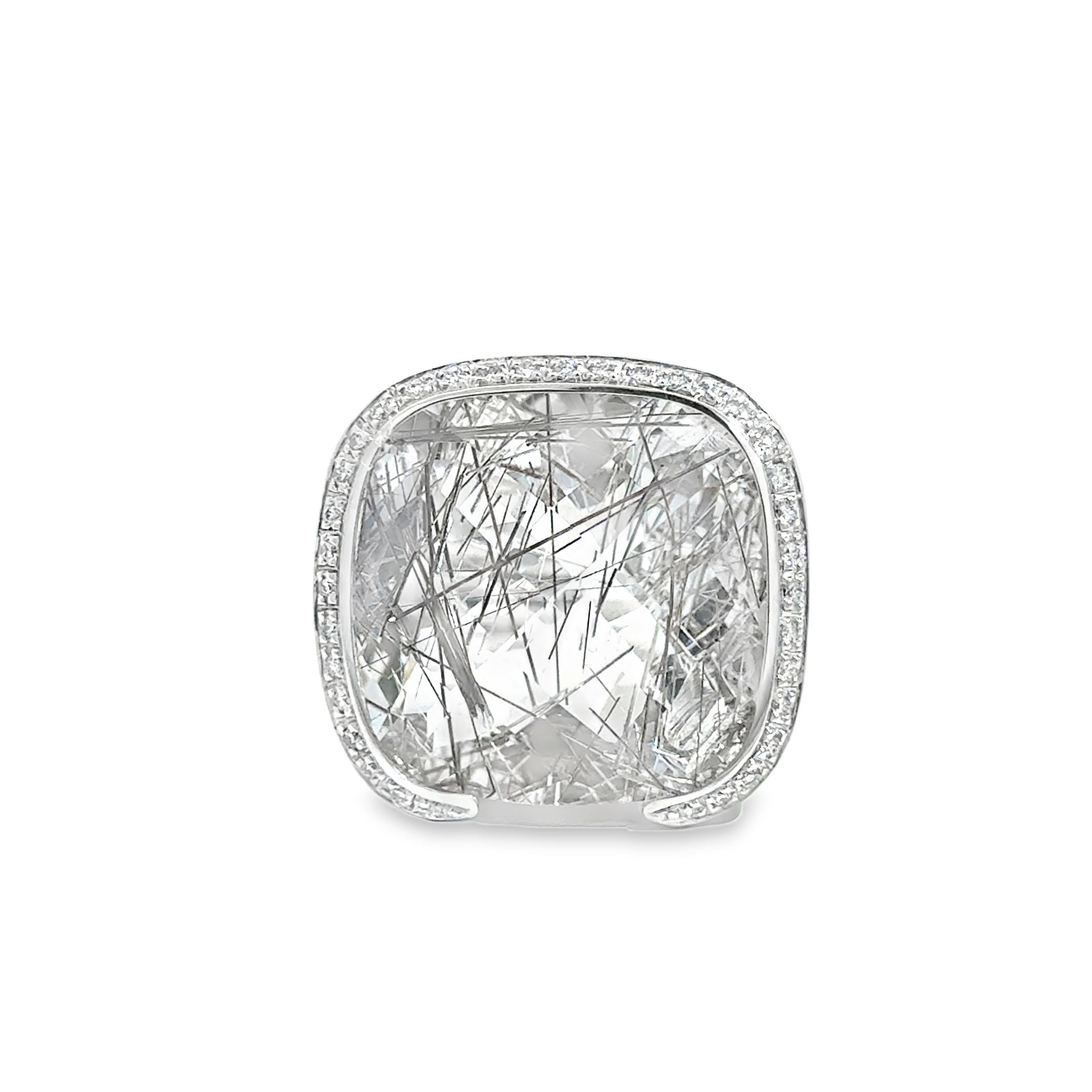 Dieser auffällige Ring aus 18 Karat Weißgold zeigt einen kühnen Quarz im Kissenschliff, der von einem Halo aus runden Brillanten von insgesamt ca. 0,50 Karat umrahmt wird. Das einzigartige geometrische Design hebt die natürliche Klarheit und die
