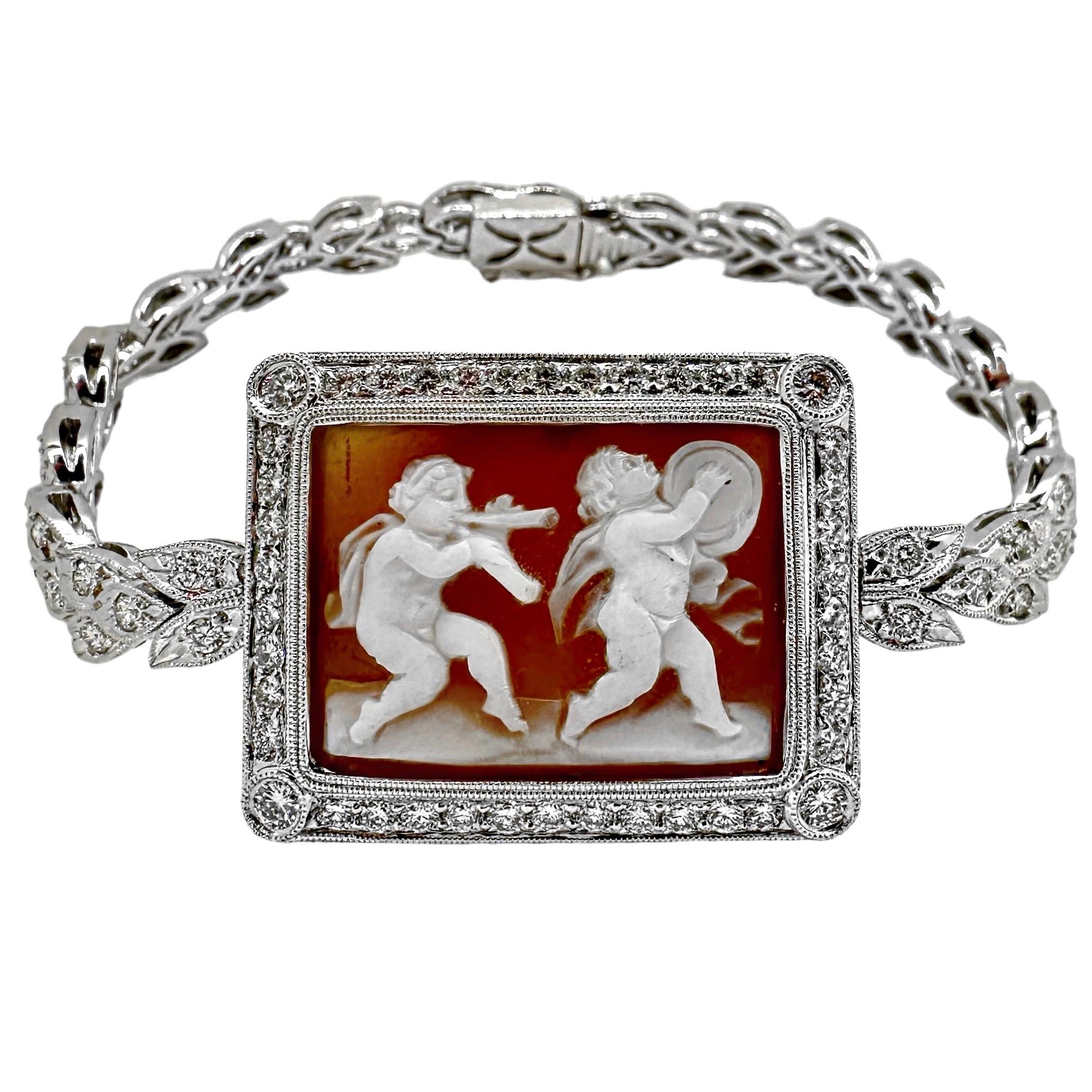 Brazalete de oro blanco de 18 quilates centrado en torno a un camafeo rectangular, de concha, de dos cupidos. Los putti están enmarcados con un borde milgrain y un borde de diamantes engastados en pavé, con diamantes engastados en bisel puntuando