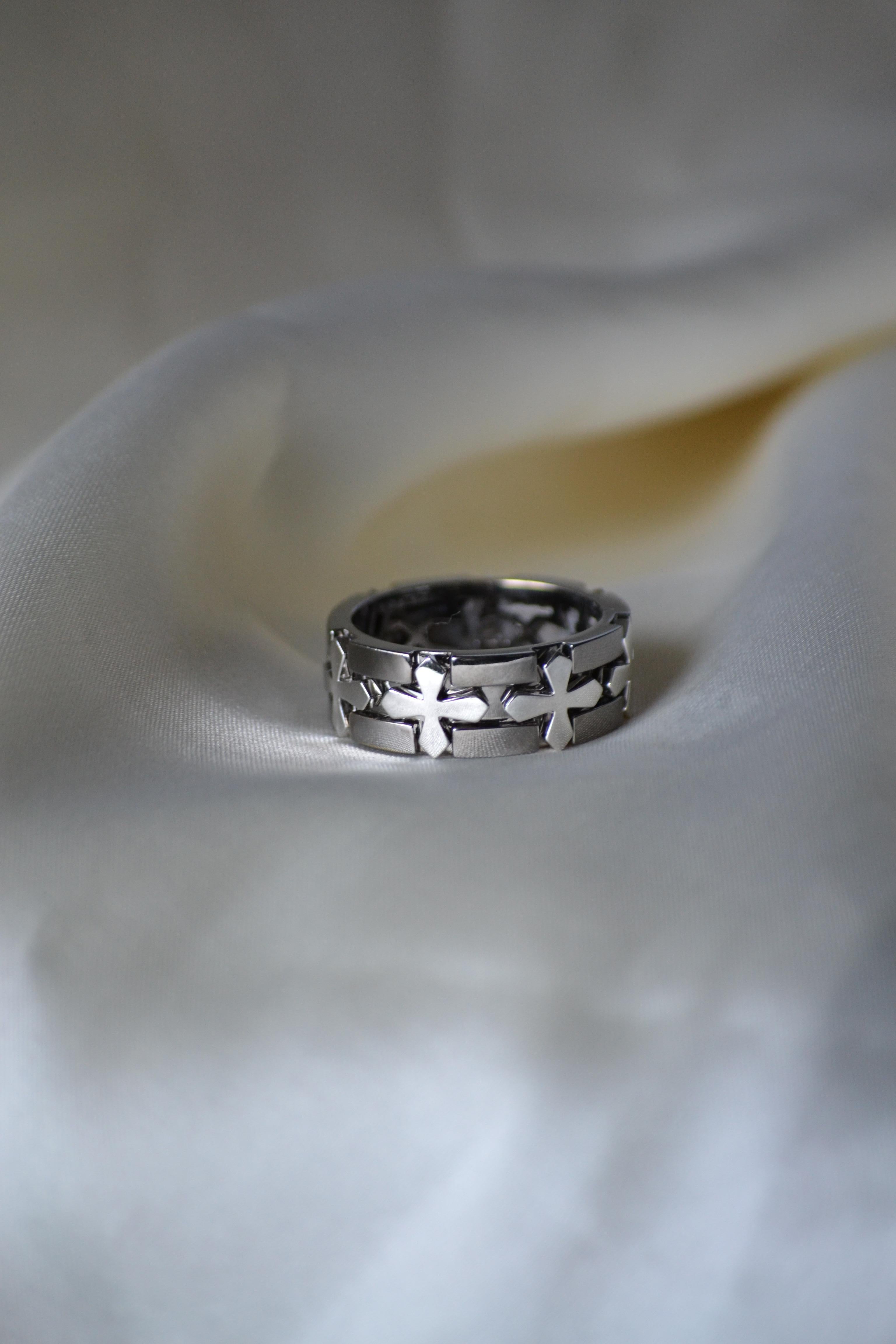 Audace nel simbolismo e moderno nel design, questo anello in oro bianco 18 carati con finitura in rodio nero presenta un sorprendente motivo a croce che parla sia di forza che di stile. Le croci in oro bianco lucido contrastano nettamente con lo
