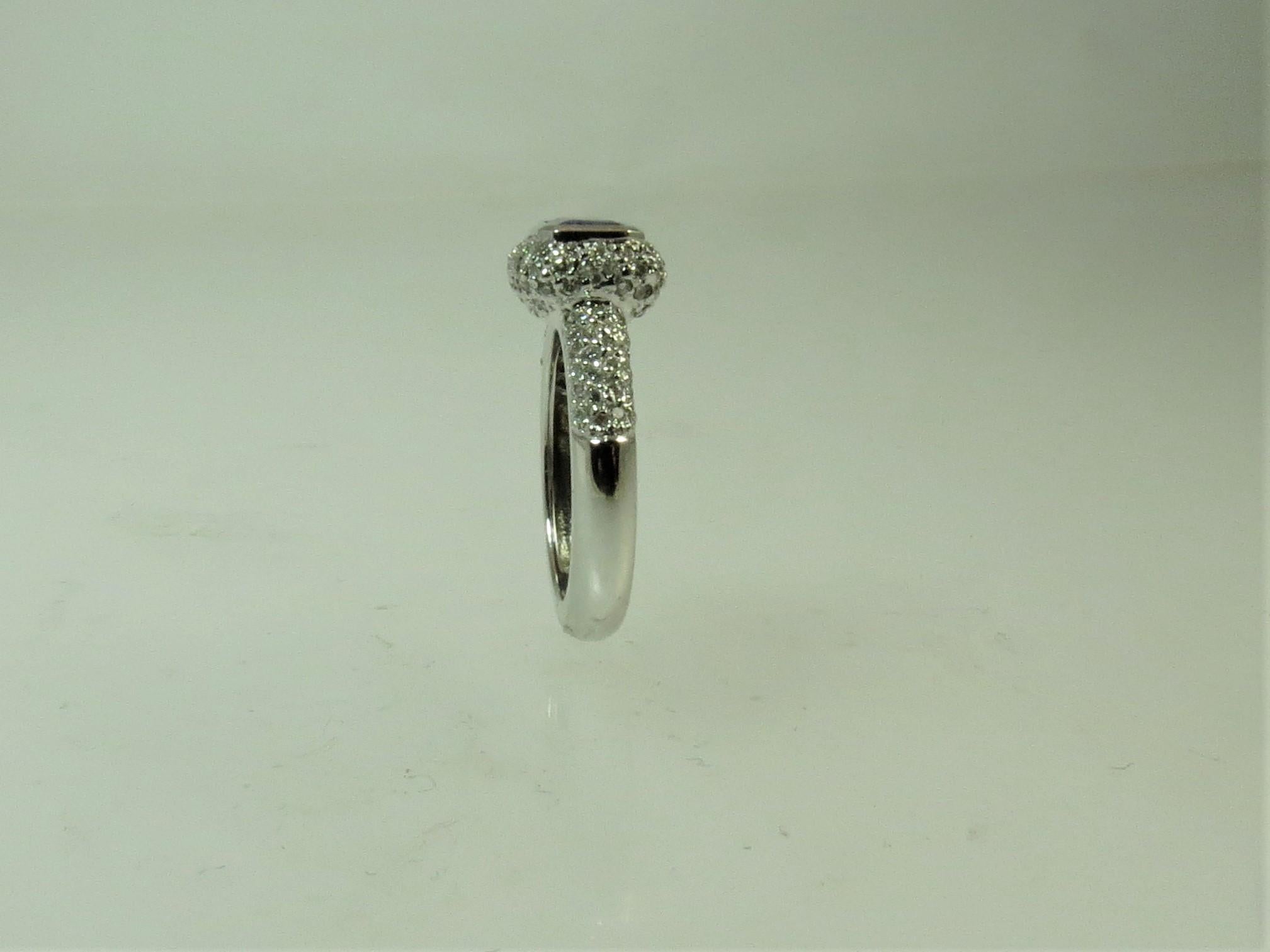 Contemporary 18 Karat Gold Ring Bezel Set with Emerald Cut Tanzanite and Pavé Set Diamonds For Sale