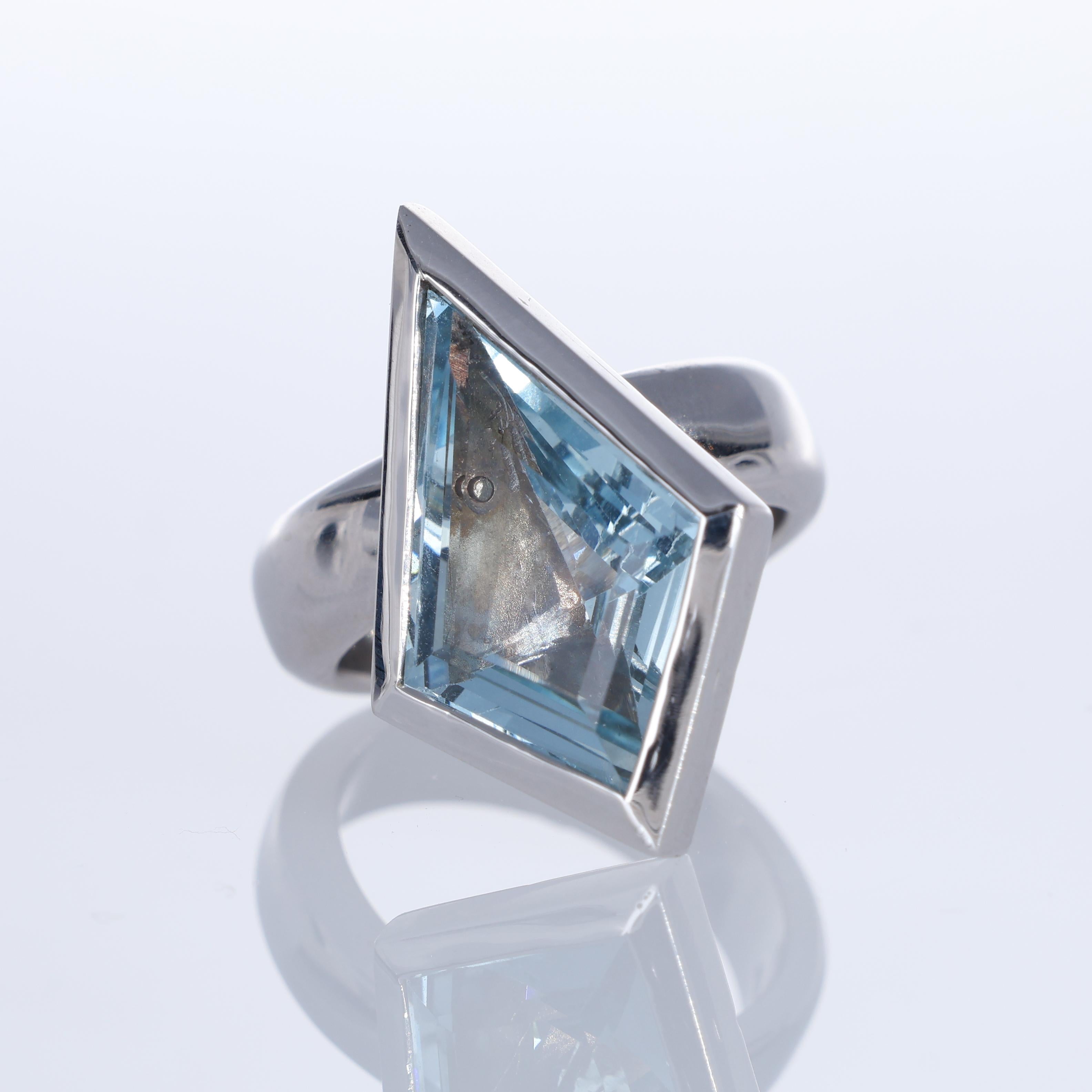 A bold and contemporary 18K white gold ring featuring a striking 7.07-carat rhombus-cut aquamarine. The geometric bezel setting enhances the gemstone's angular brilliance, creating a statement piece with a modern edge. The substantial gold band