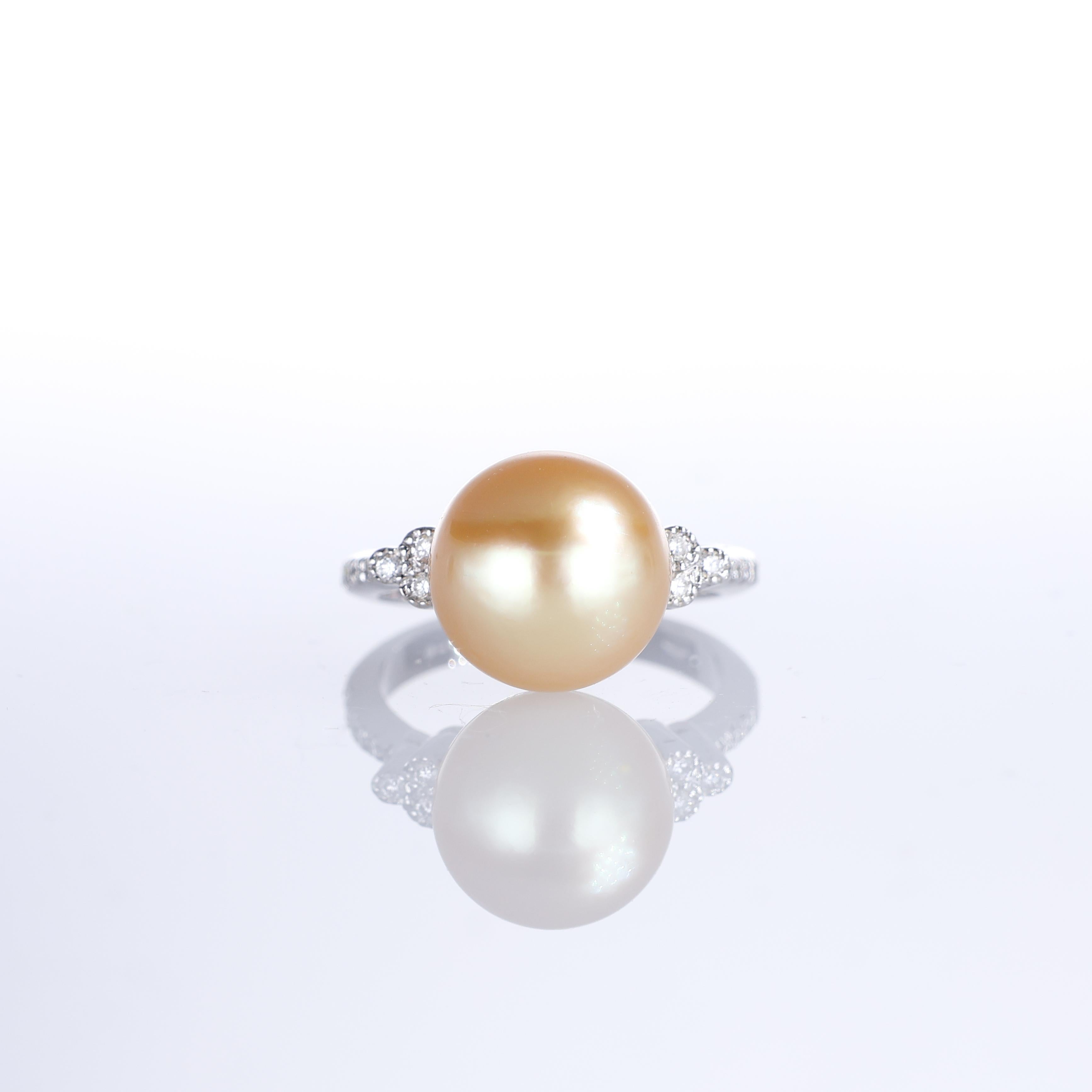 An 18K white gold ring featuring a striking golden pearl at its center, flanked by natural white diamonds along the band, totaling 0.30 carats. The contrast between the warm glow of the pearl and the brilliance of the diamonds creates a refined yet