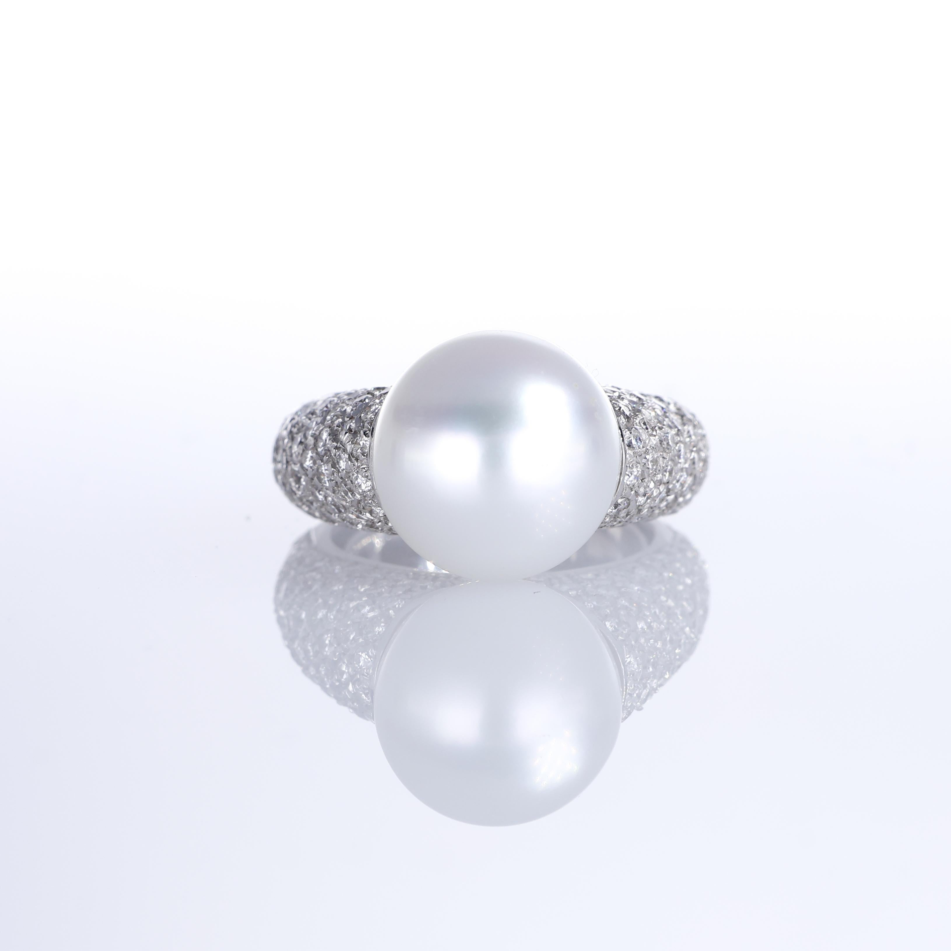 A striking 18K white gold ring featuring a luminous 15mm central pearl, surrounded by an elegant pavé setting of natural white diamonds totaling 1.41 carats. The refined balance of shimmering diamonds and the smooth, lustrous pearl creates a