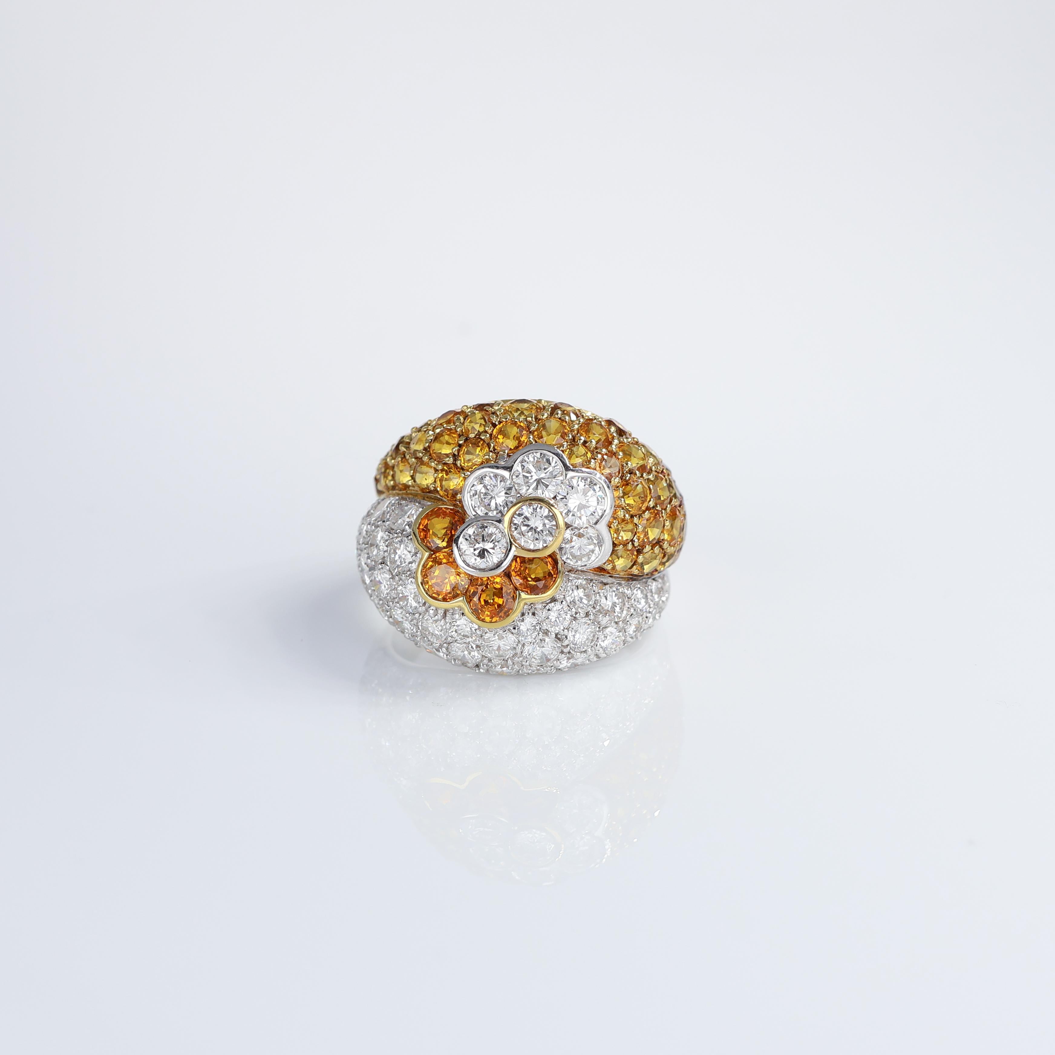 Questo lussuoso anello in oro bianco 18 carati presenta un accattivante design a pavé ornato da 2,10 carati di diamanti bianchi brillanti e 4,10 carati di vibranti zaffiri gialli. Il fulcro di questa elegante creazione è un motivo floreale che fonde