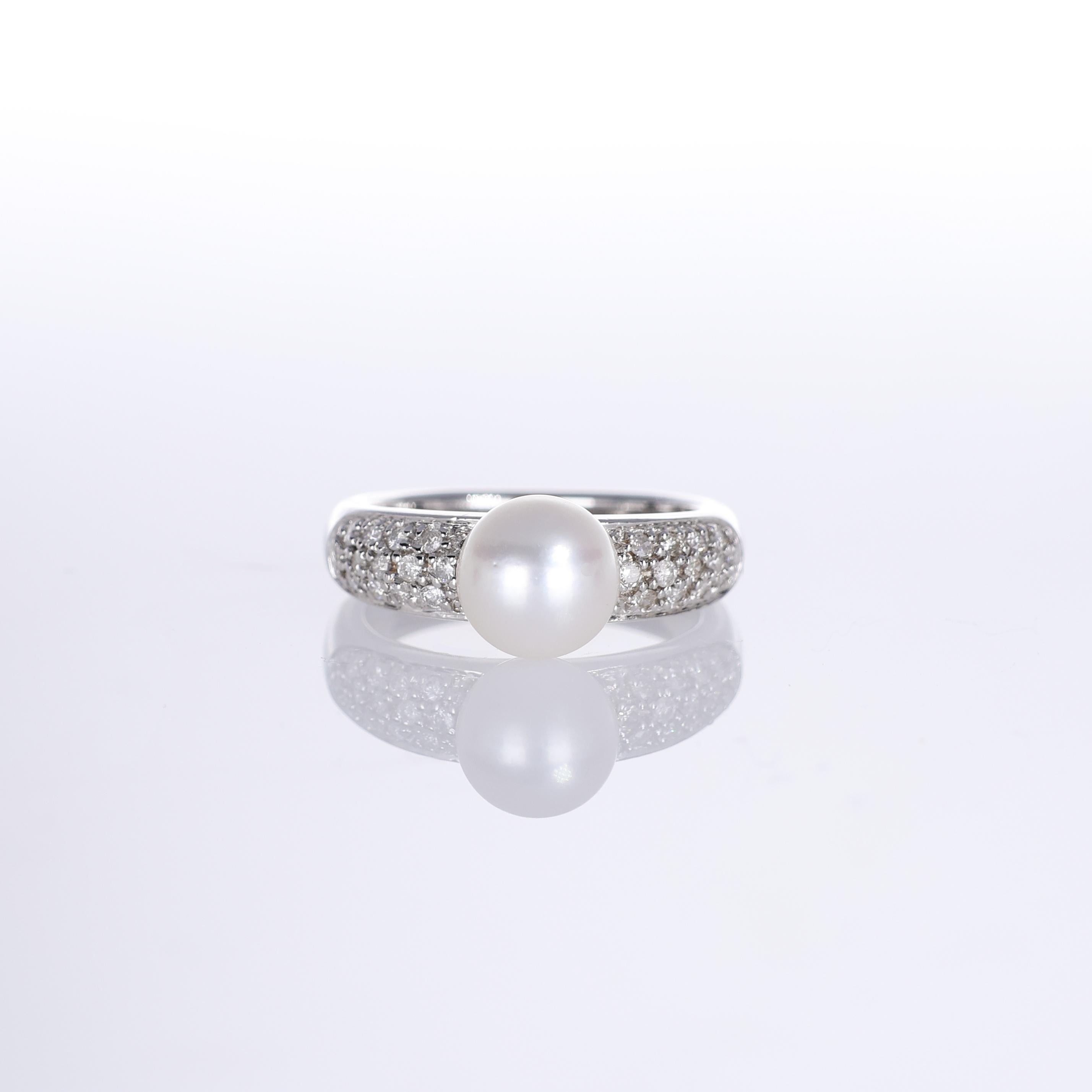 An elegant 18K white gold ring featuring a lustrous 7.5mm white pearl, set between pavé-set brilliant-cut diamonds. The refined design enhances the natural beauty of the pearl, while the diamonds add a subtle yet striking brilliance. A timeless