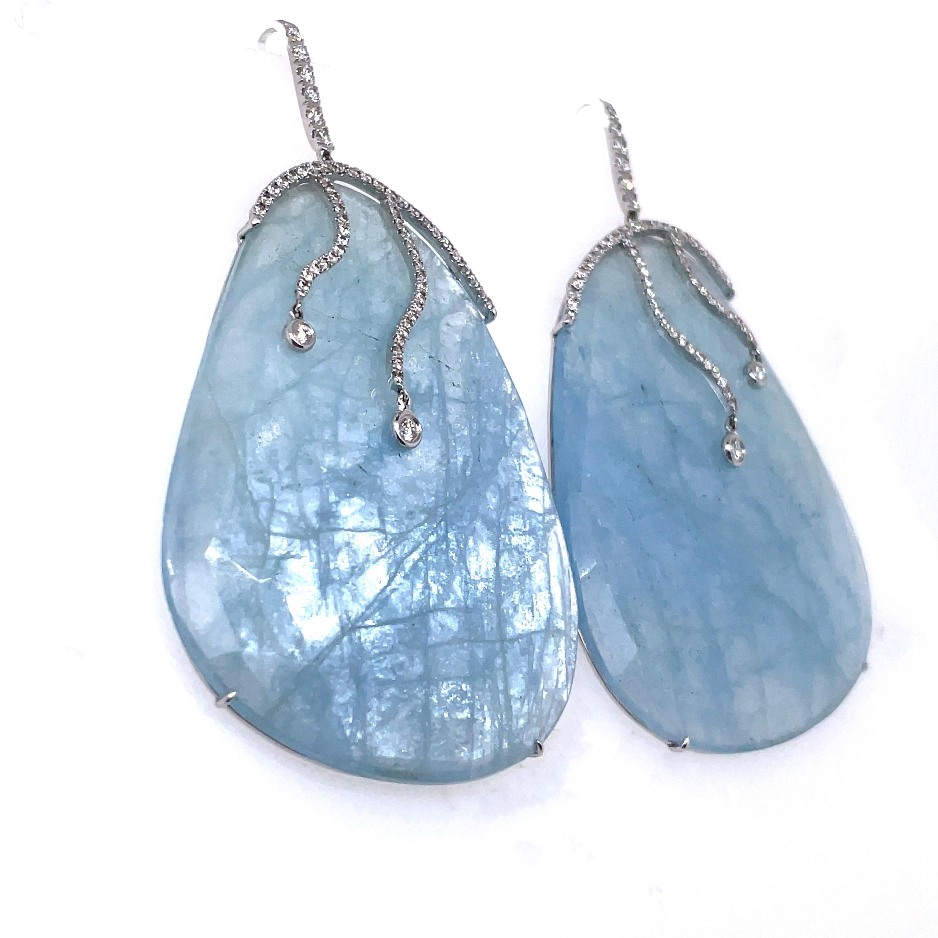 Like luscious fruits dangling from delicate stems, these earrings feature two mesmerizing rose cut aquamarine gems sourced from the depths of Brazil's mines, totaling an impressive 120.53 carats.

They are elegantly embraced by 124 round diamonds,