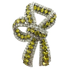 Broche lazo de oro blanco de 18 quilates con diamantes talla rosa y zafiro amarillo