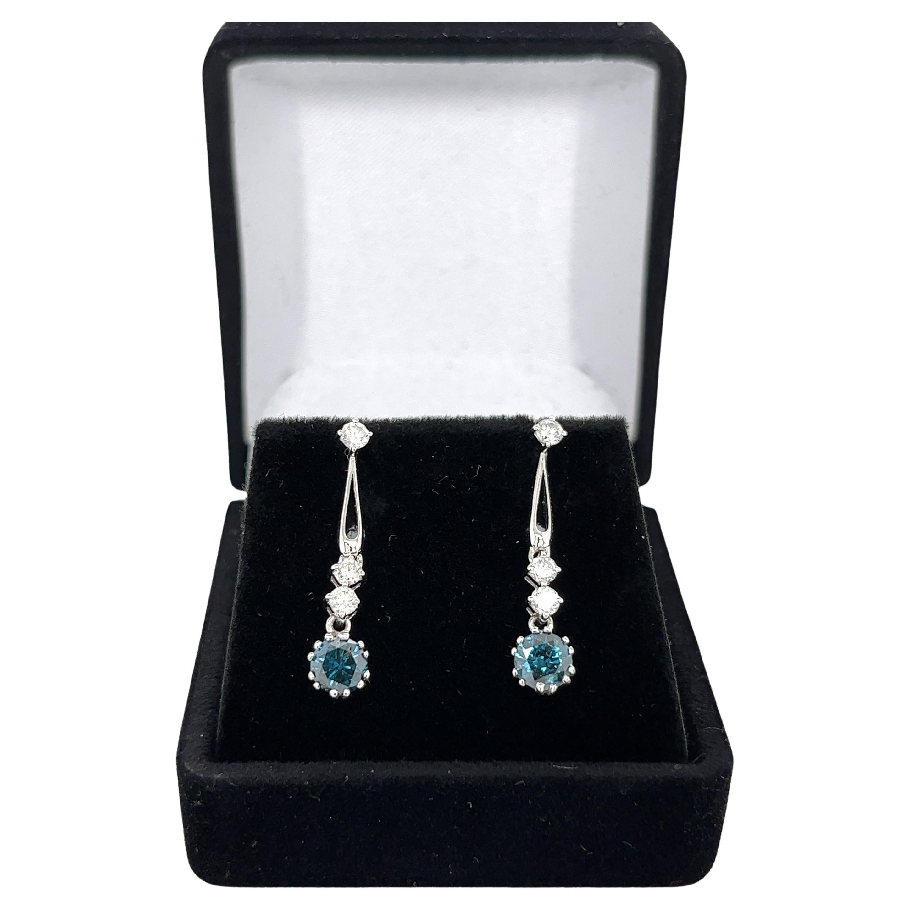 Natural blue and white diamond drop earrings set in 18 karat white gold and push-back closure. 

These earrings are the perfect balance of extravagance and minimalism. Shiny 18k white gold and sparkly natural diamonds that match any look and season.