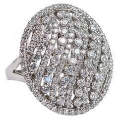 Anello da cocktail di grande effetto in oro bianco 18 carati, con diamanti disposti a grappolo su una base traforata a forma di onda