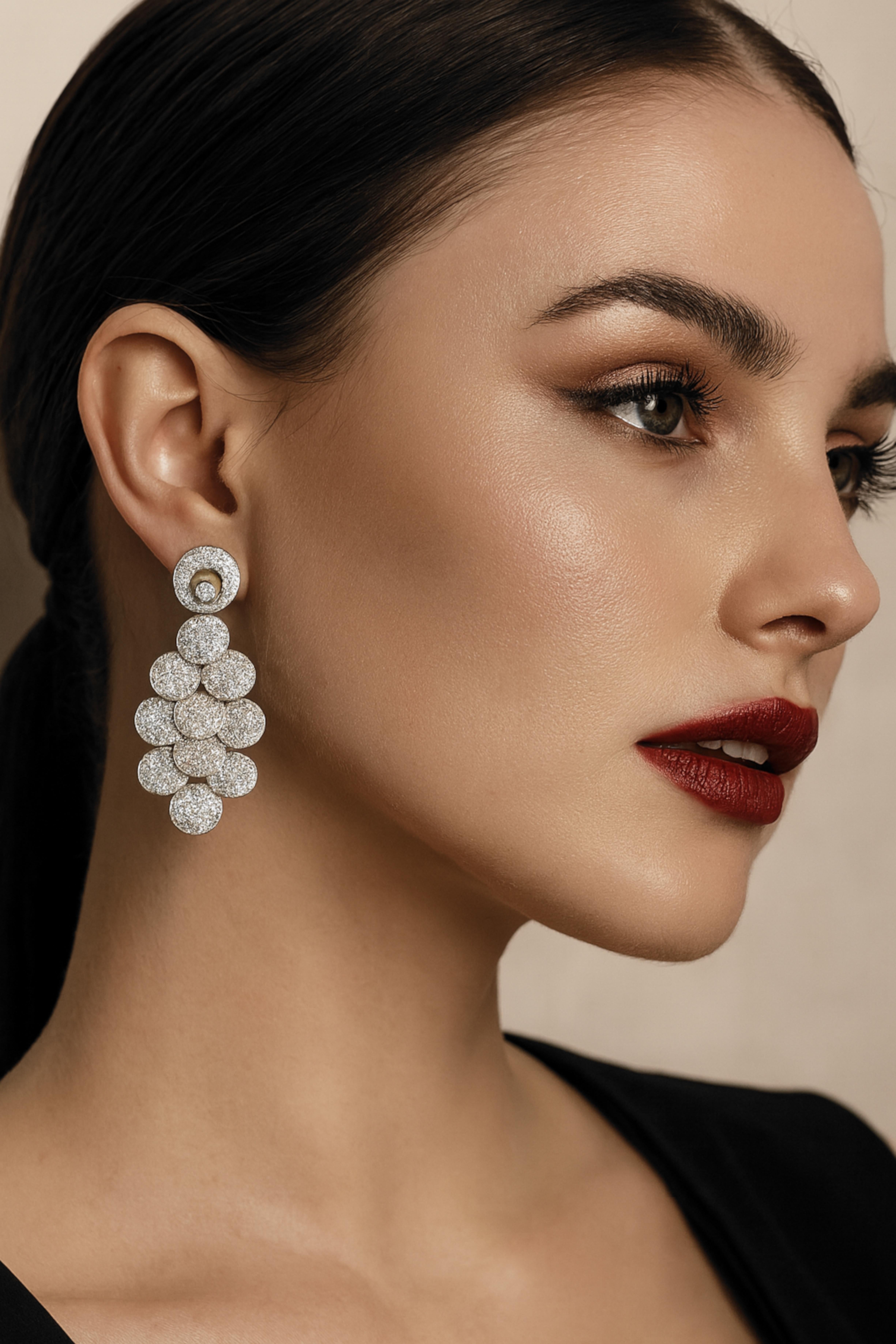 18K White Gold Round Pave Diamond Circle Chandelier Earrings

Crafted in luxurious 18K white gold with a substantial weight of 20.3 grams, these chandelier earrings dazzle with 436 round pave-set diamonds totaling 6.50 carats. The elegant design