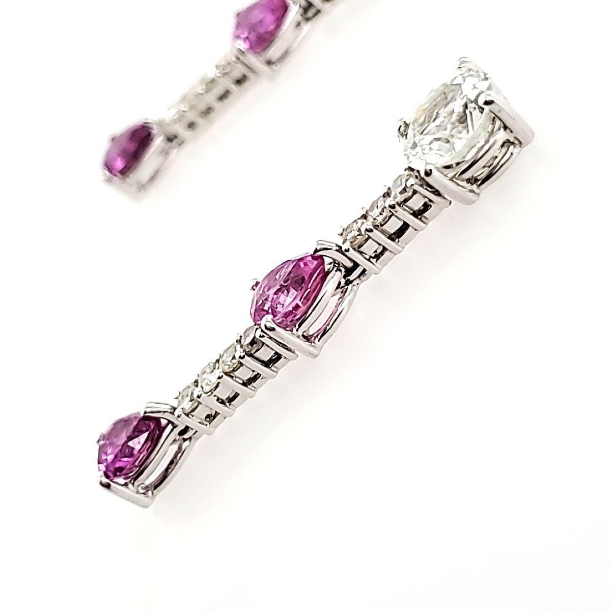 Une symphonie de pierres précieuses enchanteresses dansant délicatement sur vos lobes.

Ces boucles d'oreilles présentent 2 saphirs blancs ronds provenant des terres enchanteresses du Sri Lanka, embrassant 4 saphirs roses poires, une véritable