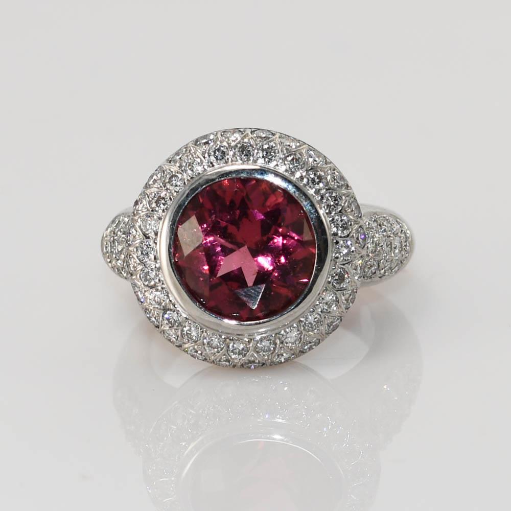 Maßgefertigter Ring mit Rubellit-Turmalin und Diamant.
Die Fassung aus 18 Karat Weißgold ist mit 18 Karat gestempelt und wiegt brutto 14,6 Gramm.
Der Rubellit wiegt 3,75 Karat und hat eine schöne rosarote Farbe.
Die seitlichen Diamanten sind runde