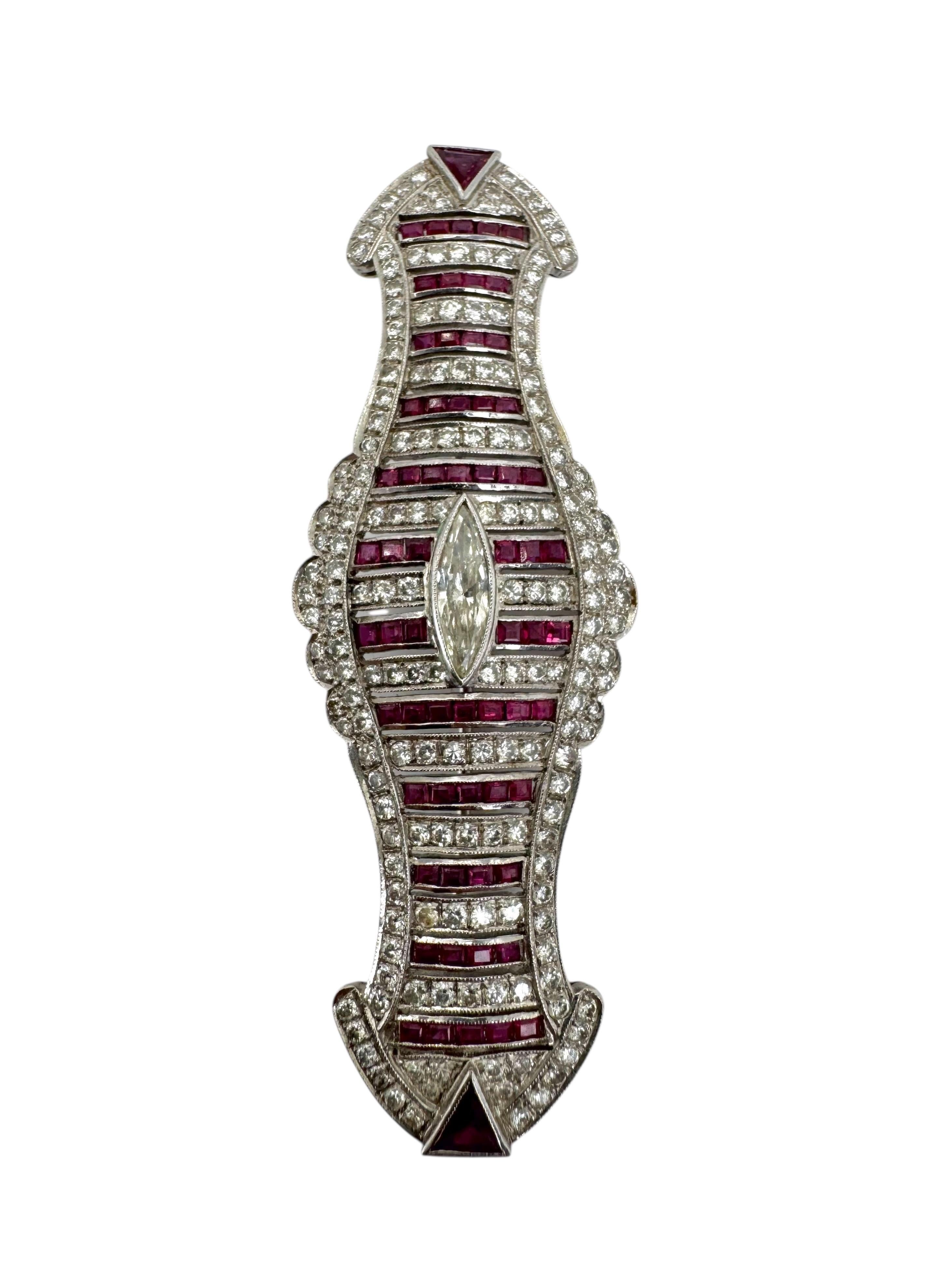 Réalisée en or blanc 18 carats lumineux, cette broche audacieuse et élégante présente un étonnant motif d'inspiration Art déco centré sur un diamant taille marquise de 0,52 carat. La pièce est richement sertie d'environ 3 carats de rubis vifs et de