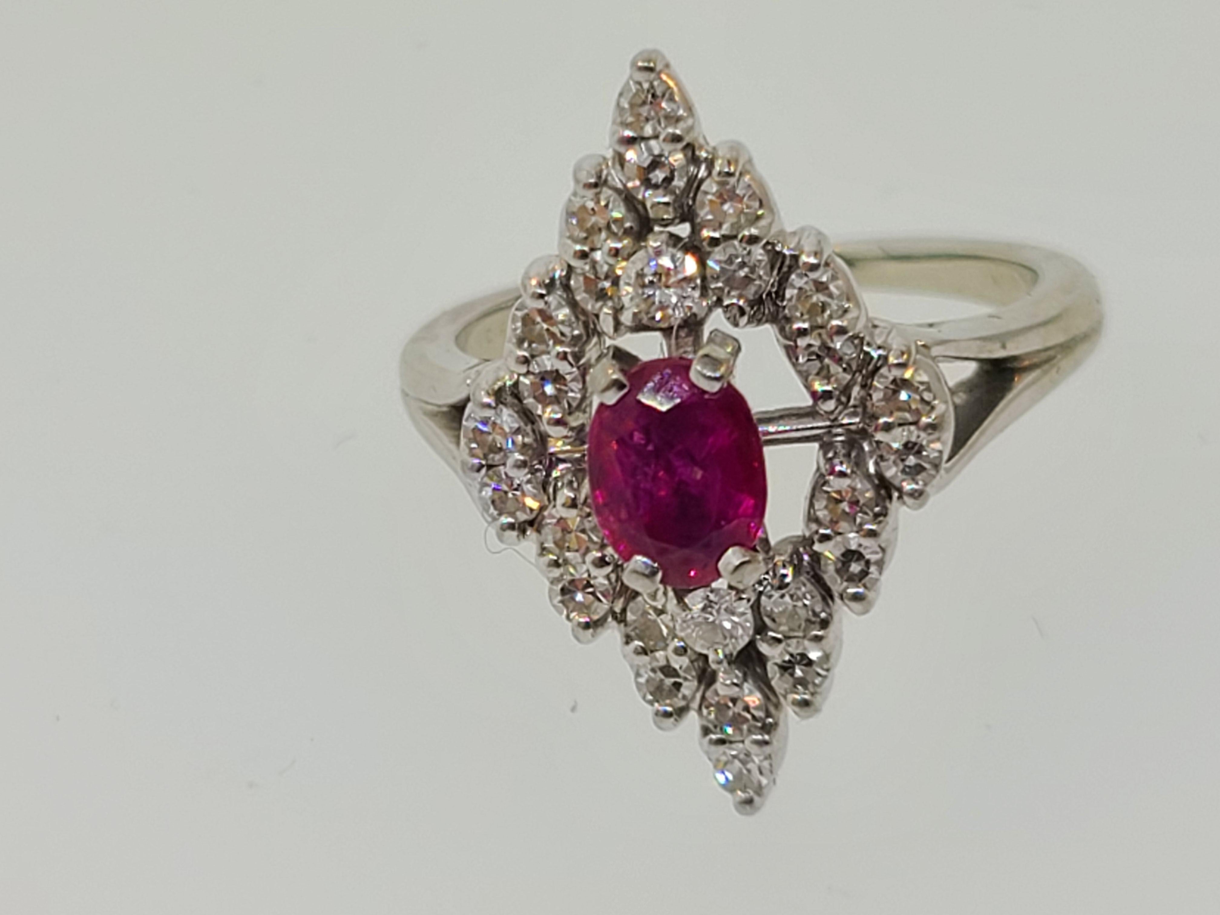 This wonderful estate found 18K white gold cocktail ring has a 5.7x4.4mm oval cut lab created ruby center stone surrounded by a cluster of 26 round cut diamonds in a diamond shape. There is some wear to the rhodium plating. 
Ring size 6 (US)
Total