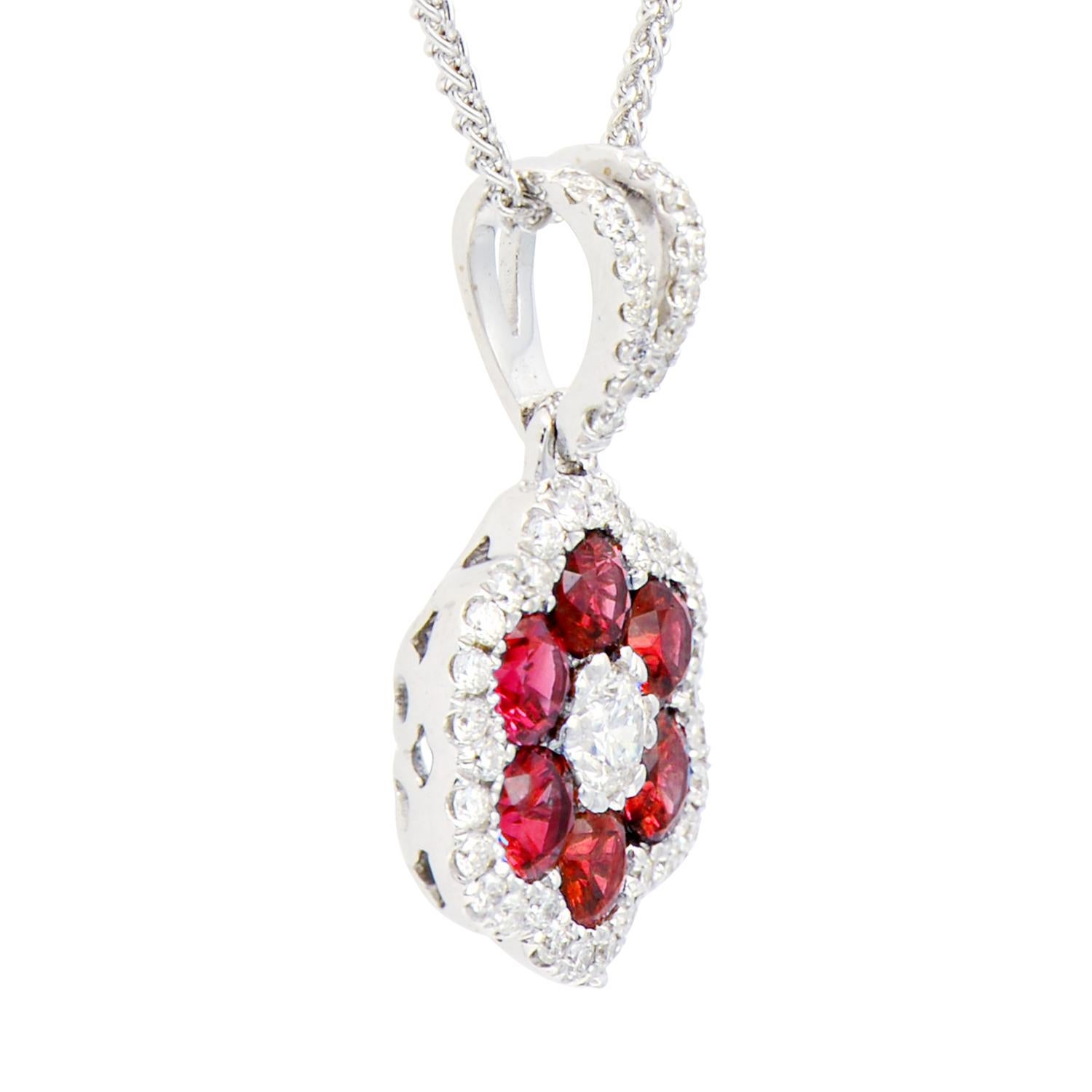 This beautiful pendant is made from 1.8 grams of 18 karat white gold. The flower shape is made from 6 rubies totaling 0.73 carats with VS2, G color diamonds for the center and as a halo around the rubies as well as on the bail of the pendant. There