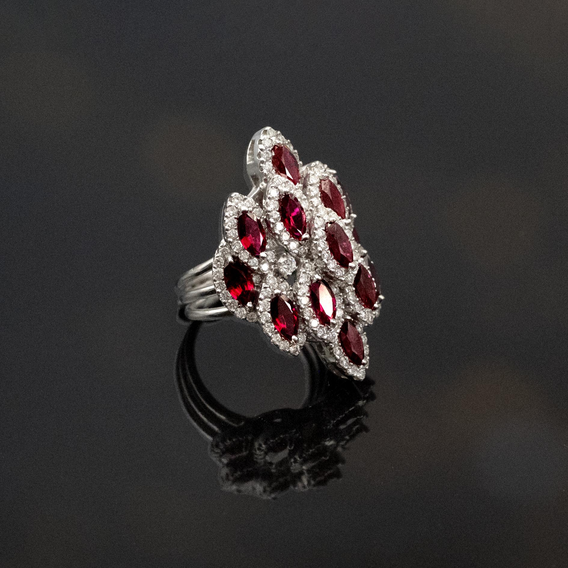 Dieser auffällige Cocktailring von Claris.A ist aus 18 Karat Weißgold gefertigt und besticht durch eine kühne, architektonische Anordnung von Rubinen und Diamanten. Das Design setzt sich aus mehreren Rubinen im Marquiseschliff zusammen. Sie sind