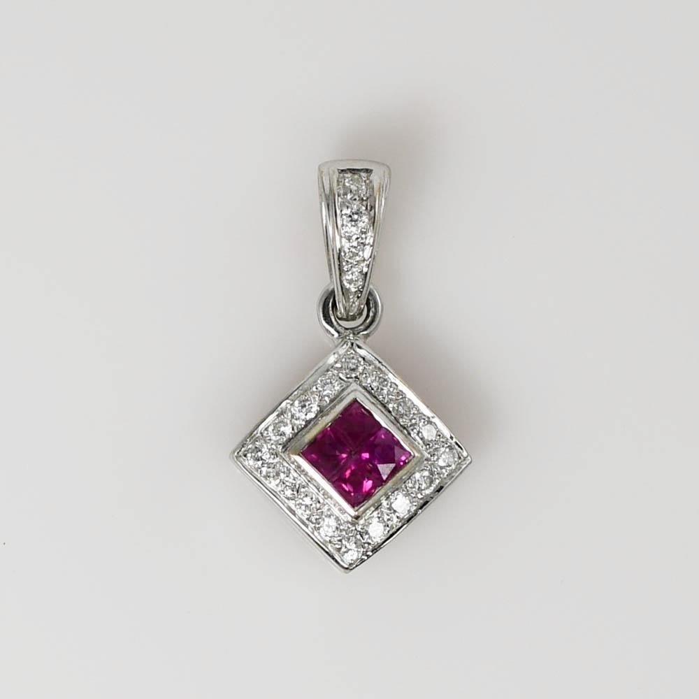 18k white gold pendant with rubies and diamonds.
Stamped 750 and weighs 3.1 grams gross weight.
The four rubies are square cuts, .20 total carats , excellent red color.
The side diamonds are round brilliant cuts, g, h, i color range, Si clarity,