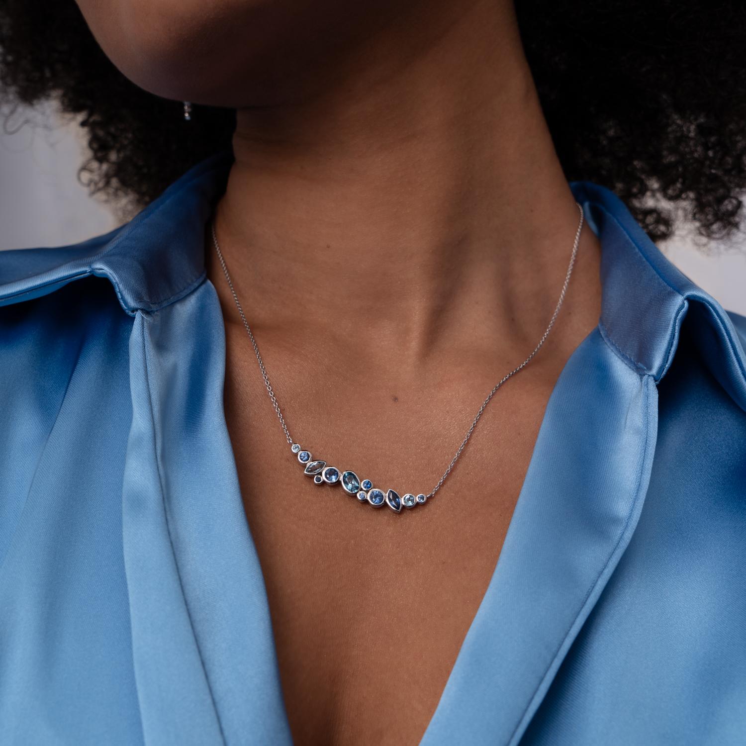 Luxuriously handcrafted in 18k white gold, this elegant Cascade pendant features a radiant ombre mix of 12 blue sapphires and aquamarines in different shapes including rounds, ovals and marquise. The colourful gemstones are encased in rub-over