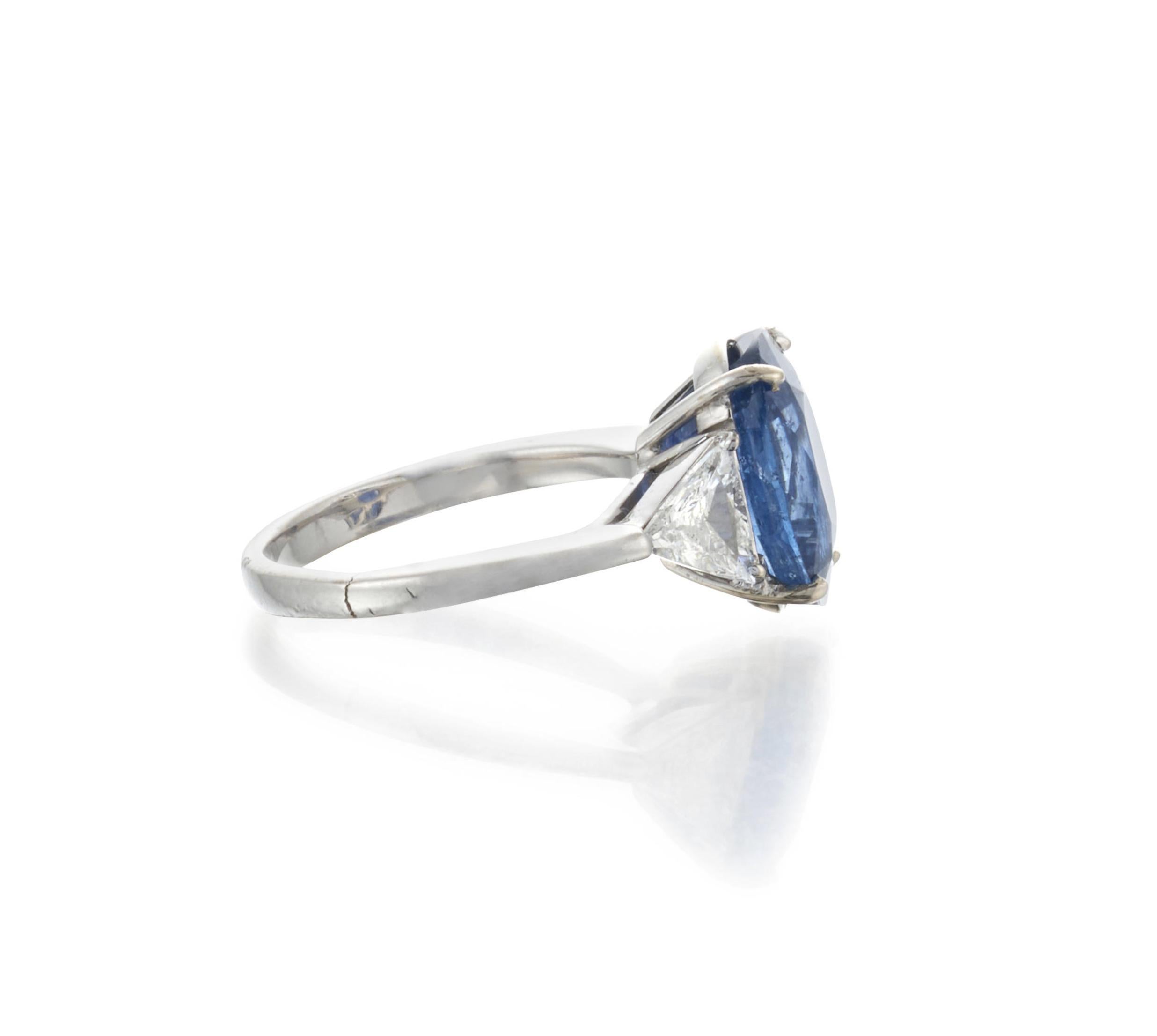 18k White Gold Sapphire Diamond Ring

Details:
Centering an oval-cut sapphire measuring approx. 11.90 x 9.35 x 6.80 mm, flanked by triangle-cut diamonds, each diamond weighing approx. 0.50 carats.
Weight of the ring: 5.4 grams
Ring size: approx.