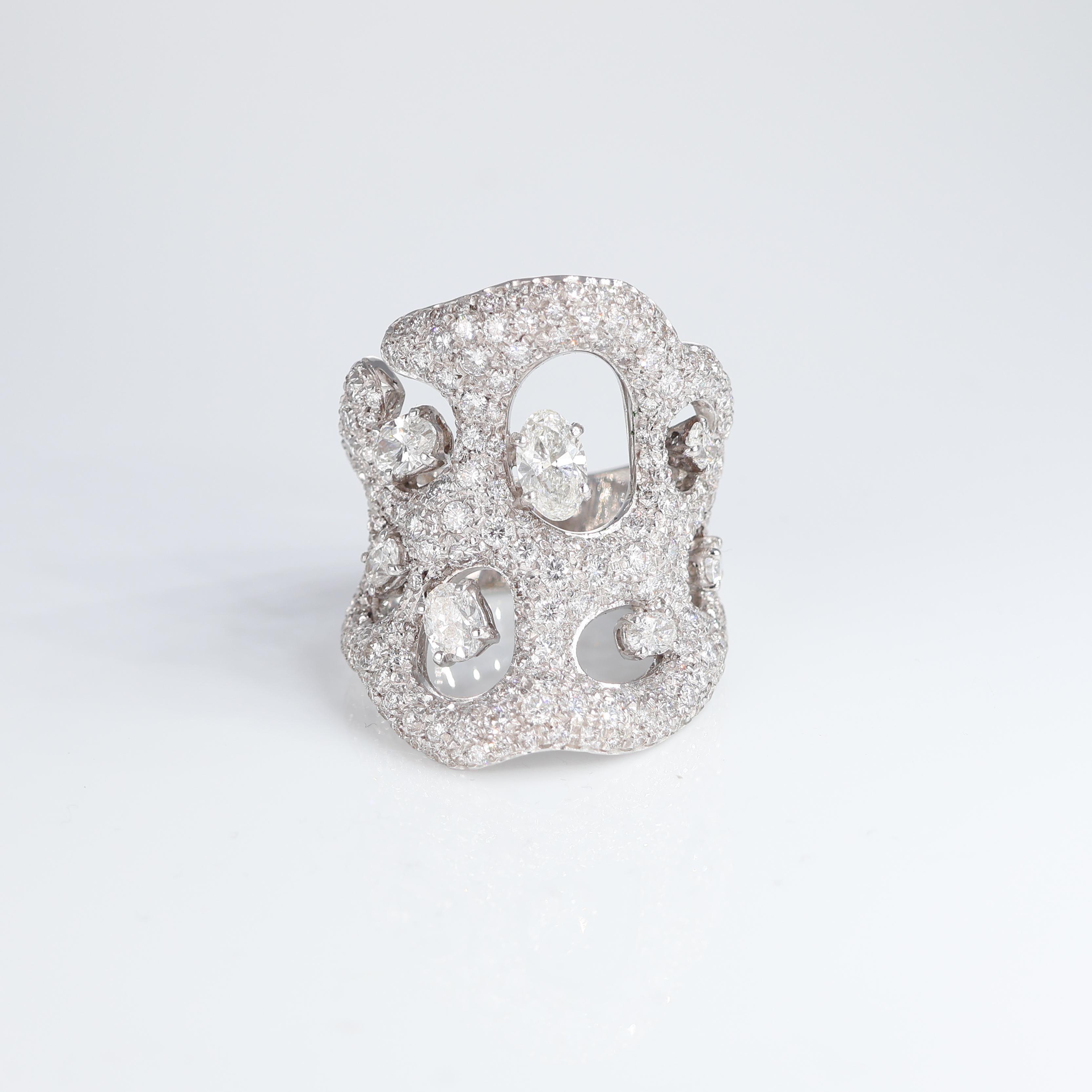 A bold and artistic creation, this 18K white gold ring features an intricate openwork design fully encrusted with pavé-set natural white diamonds totaling 2.71 carats. The fluid, sculptural form is further accentuated by individually set