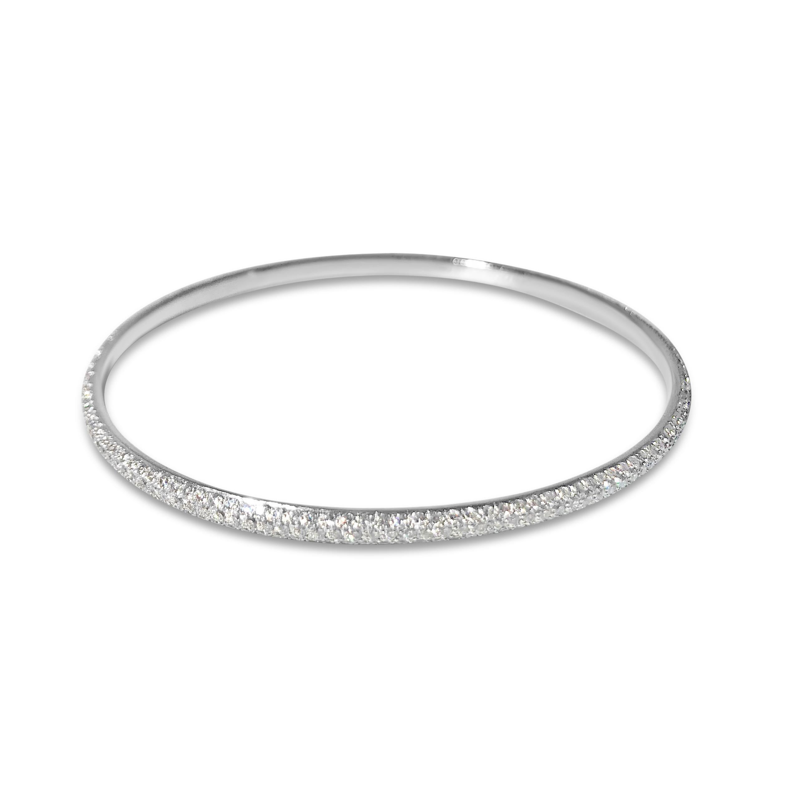 Our ultra-brilliant pavé diamond round bangle sparkles in 18K white gold, loaded with 405 round 1.3mm white diamonds totaling 3.10ct.  Meant to slip onto your wrist and shine.

Specifications:
- Stone(s): White Diamond
- Diamond-Cut & Clarity: 