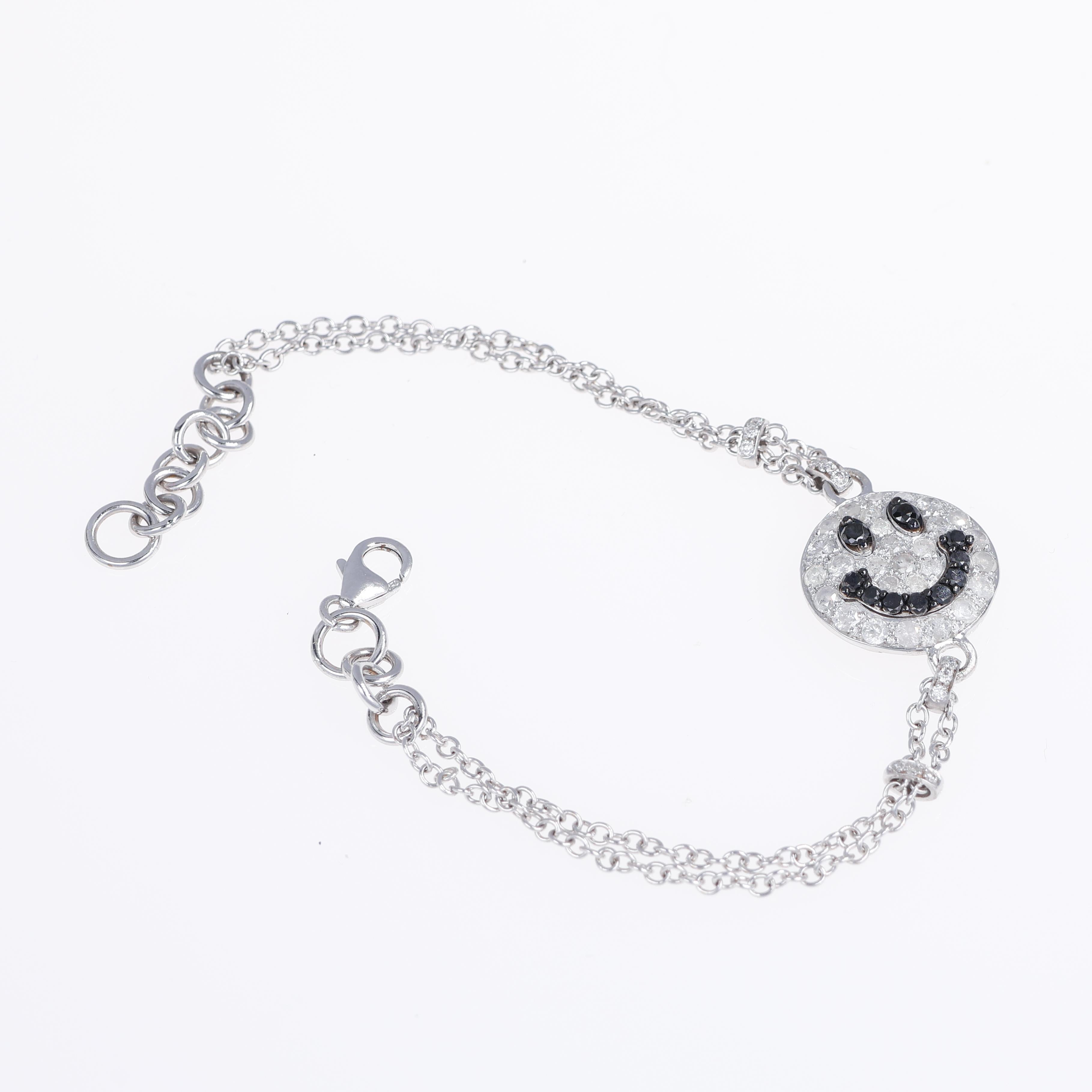 A playful and contemporary bracelet featuring a smiley face motif, crafted in 18K white gold. The design is adorned with pavé-set ice diamonds, while the eyes and mouth are accentuated with black diamonds, creating a striking contrast. The