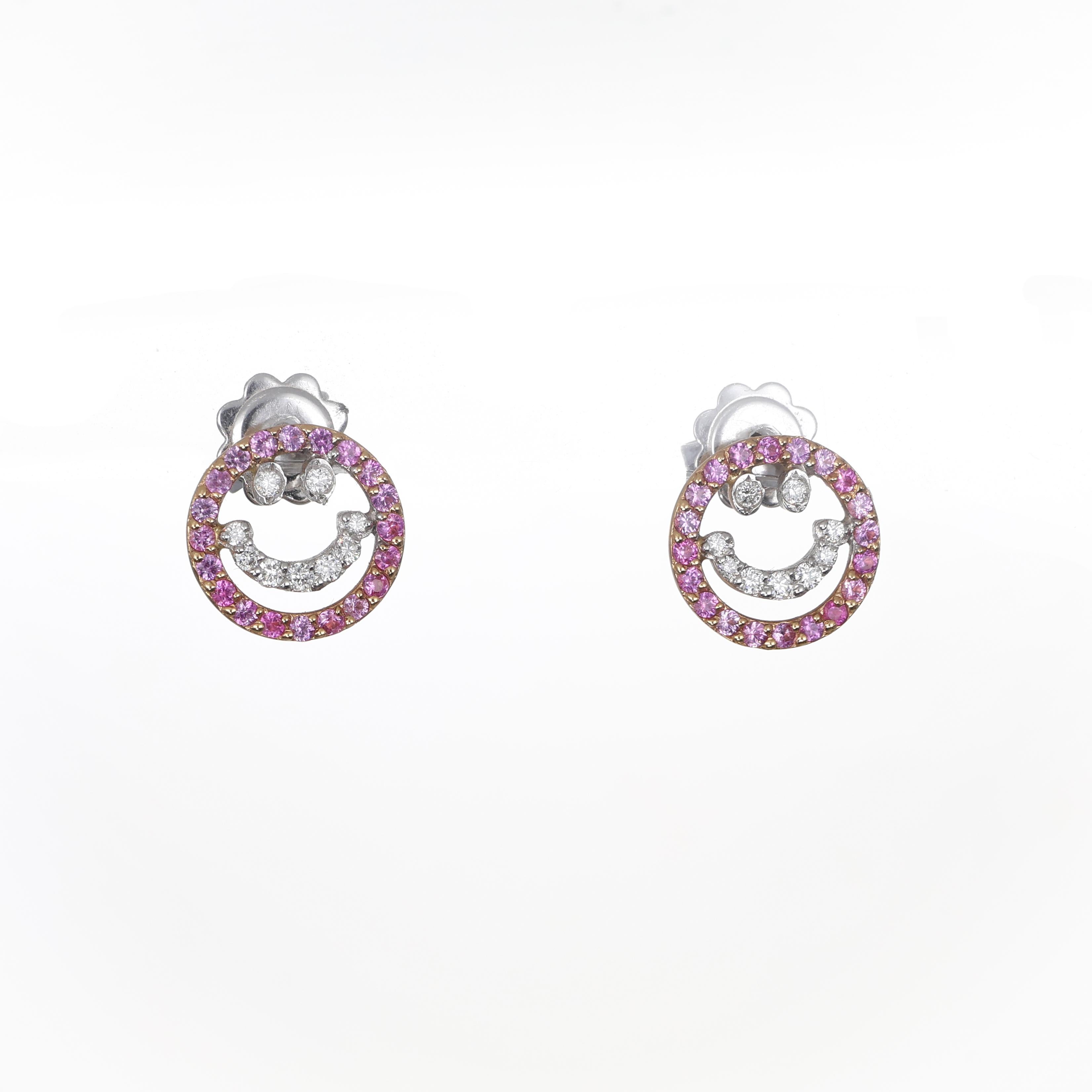 A charming and vibrant design, these 18K white gold stud earrings feature a smiley face motif encrusted with pink sapphires and brilliant-cut diamonds. The playful design is enhanced by the delicate sparkle of the gemstones, making these earrings a