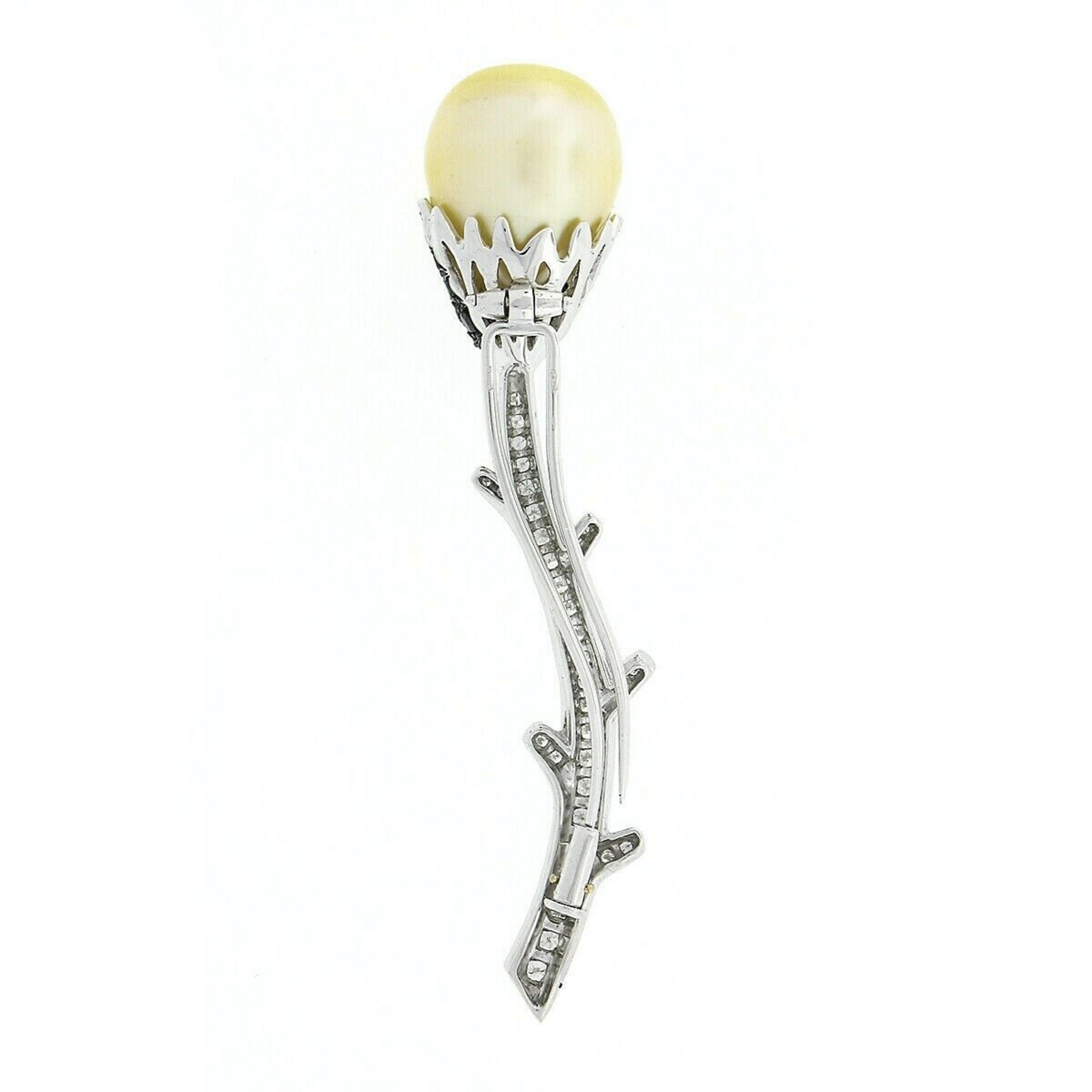 Here we have a beautiful brooch that was crafted from solid 18k white gold featuring an elegant flower design that is neatly pave set with white and fancy black diamonds and an incredible south sea pearl at its top. The pearl is stem set as the