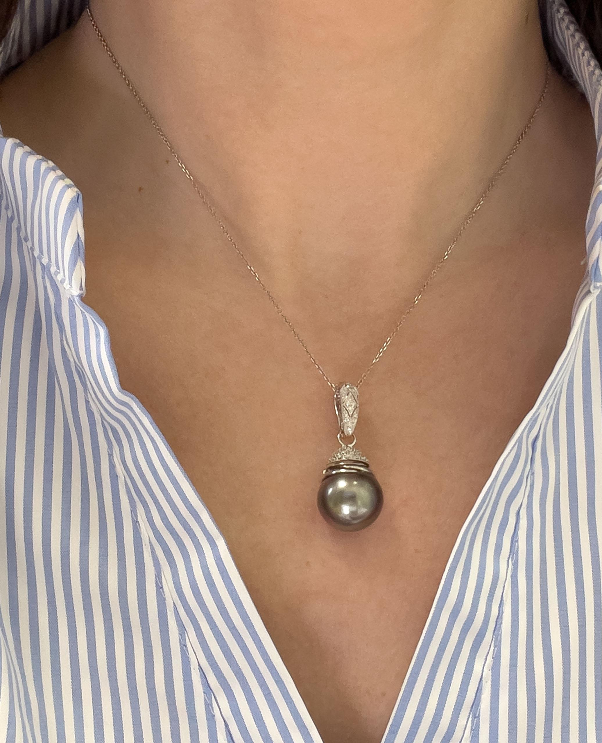 18K white gold enhancer pendant with round faceted diamonds weighing 0.30 carats total and one black Tahitian pearl measuring 14.99mm.

- Pendant slides on a 14K white gold chain, 16 inches long.
- Diamonds are H/I color, SI clarity.
- Lobster clasp