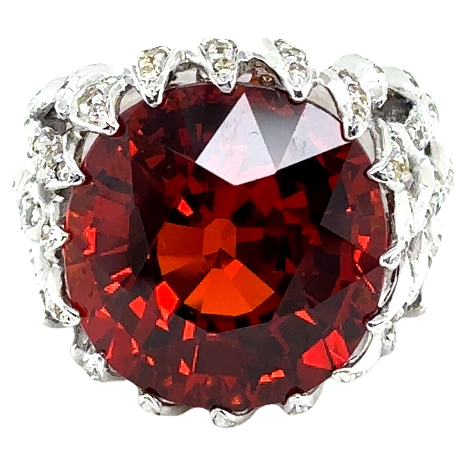 Questo splendido anello di fidanzamento presenta un granato Spessartine da 21,99 carati proveniente dalla Namibia, che brilla con ricche sfumature rosso-arancio che simboleggiano creatività e fiducia. 

Incorniciato da 2,00 carati di diamanti