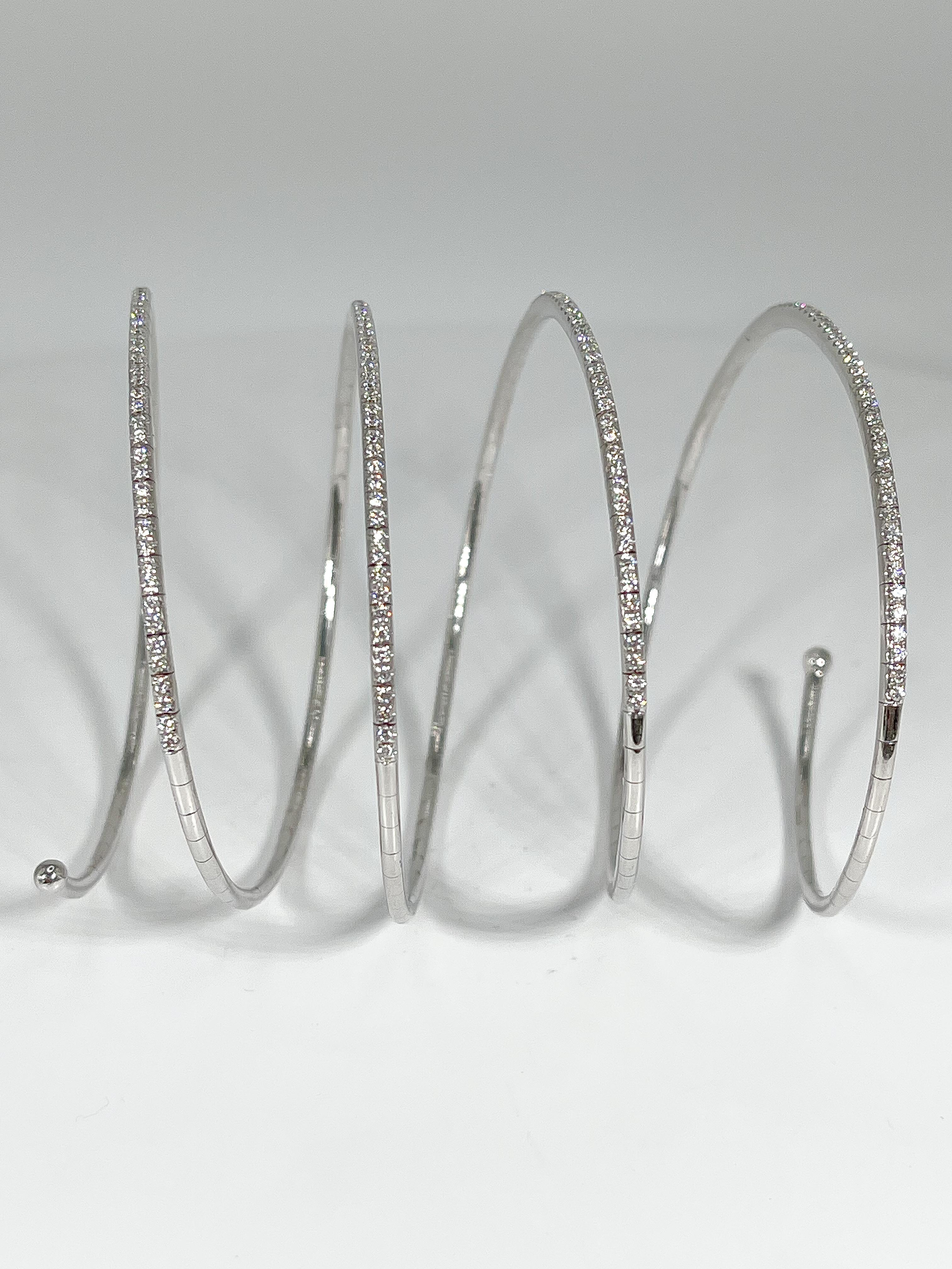This 18k white gold spiral bangle is enhanced with 208 round cut diamonds (1.50 CTW) This beautiful bracelet stretches to fit almost any wrist. The width of the individual spirals is 1.7 mm and it has a weight of 23.3 grams.