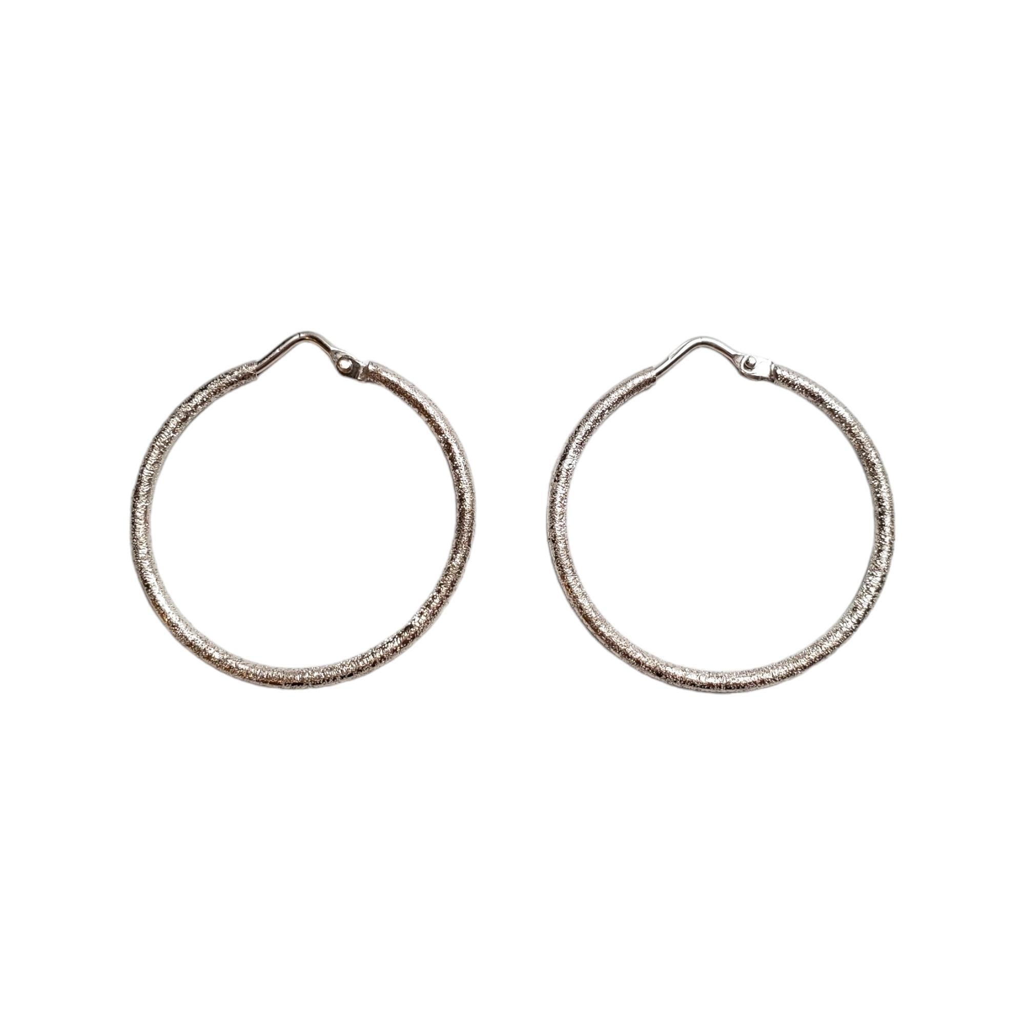 18K White Gold Stardust Hoop Earrings 

Sparkling hoop earrings with a stardust finish in 18K yellow gold.

Hallmark: 750

Weight: 3.03 g/ 1.95 dwt.

Diameter: 29.60 mm 

Width: 1.77 mm

Very good condition, professionally polished.

Will come