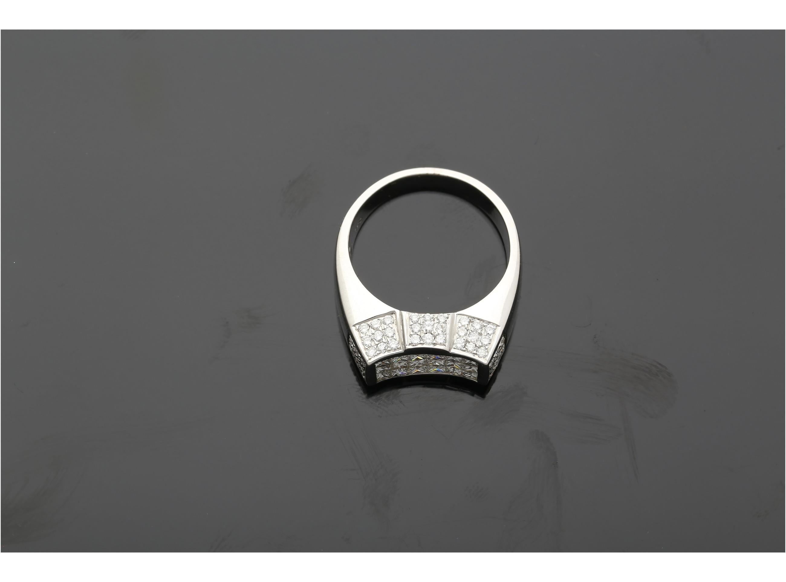 Dieser bezaubernde Ring aus 18 Karat Weißgold besticht durch 18 atemberaubende Diamanten im Princess-Schliff und 72 wunderschöne Diamanten im Rundschliff.

Dieser Ring ist für diejenigen, die einen robusten Ring mit guter Größe suchen, der täglich