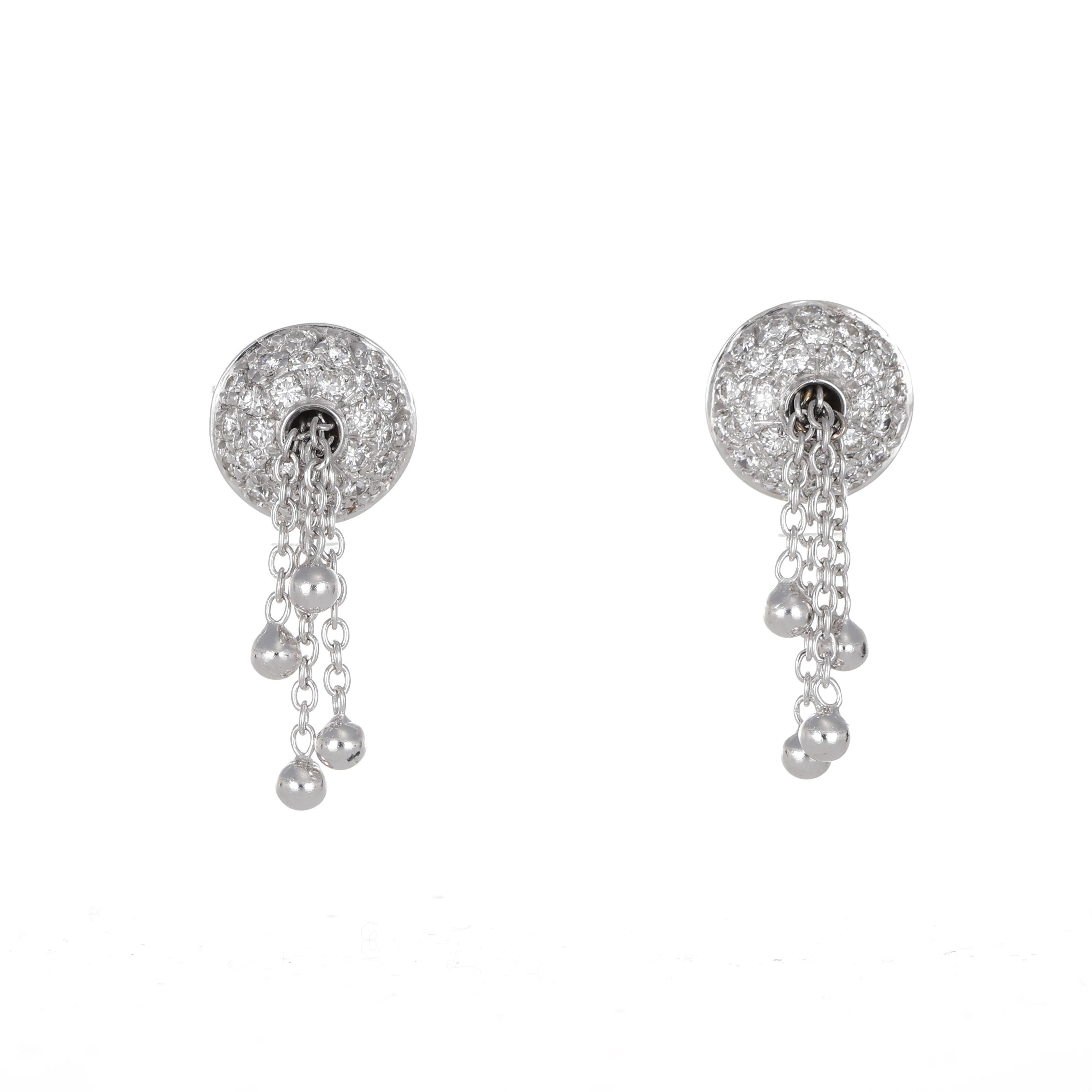 A modern and elegant pair of stud earrings crafted in 18K white gold. The round button design is enhanced with a pavé of brilliant-cut diamonds totaling 0.87 carats, while four delicate chains gracefully cascade below, adding movement and a