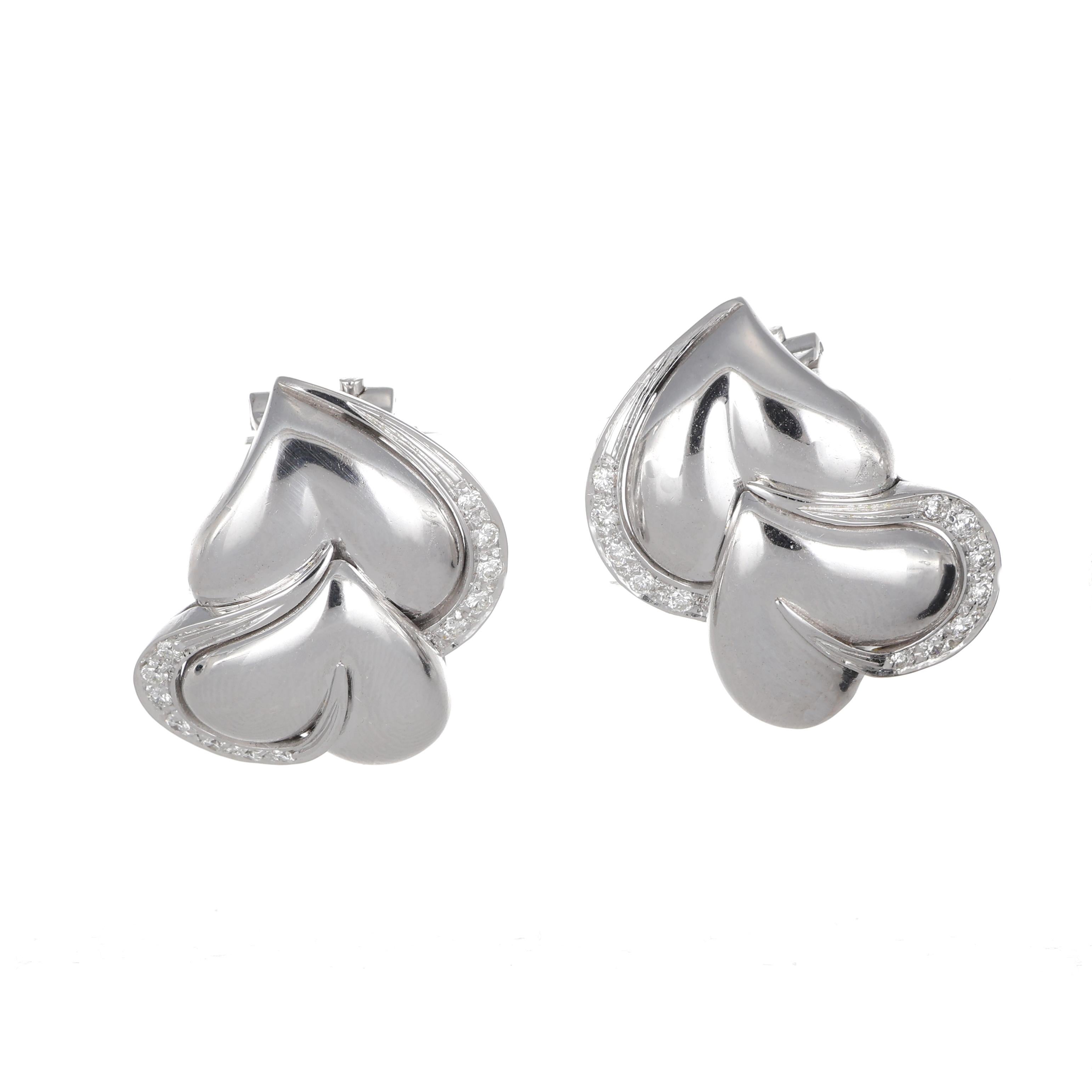 These elegant stud earrings are crafted in 18K white gold, featuring a romantic double-heart motif. The design is enhanced by a delicate pavé of brilliant-cut white diamonds, totaling 0.35 carats, which adds a touch of sparkle to the polished gold.