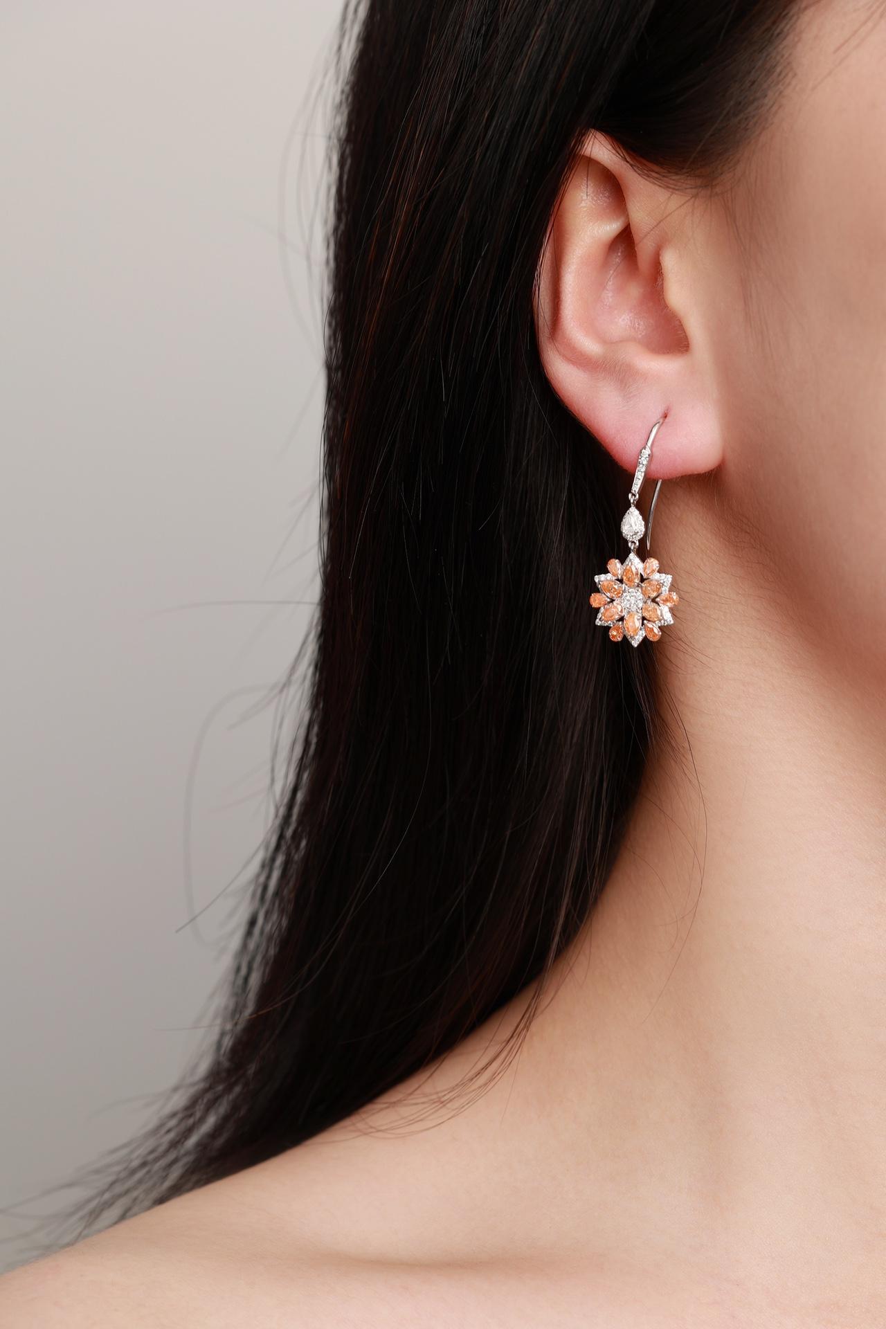18K White Gold Sunflower Drop Earrings with Orange and White Diamonds

Radiating warmth and brilliance, these stunning 18K white gold drop earrings showcase a sunflower-inspired design. Adorned with vibrant orange diamonds (2.30ct) and natural white
