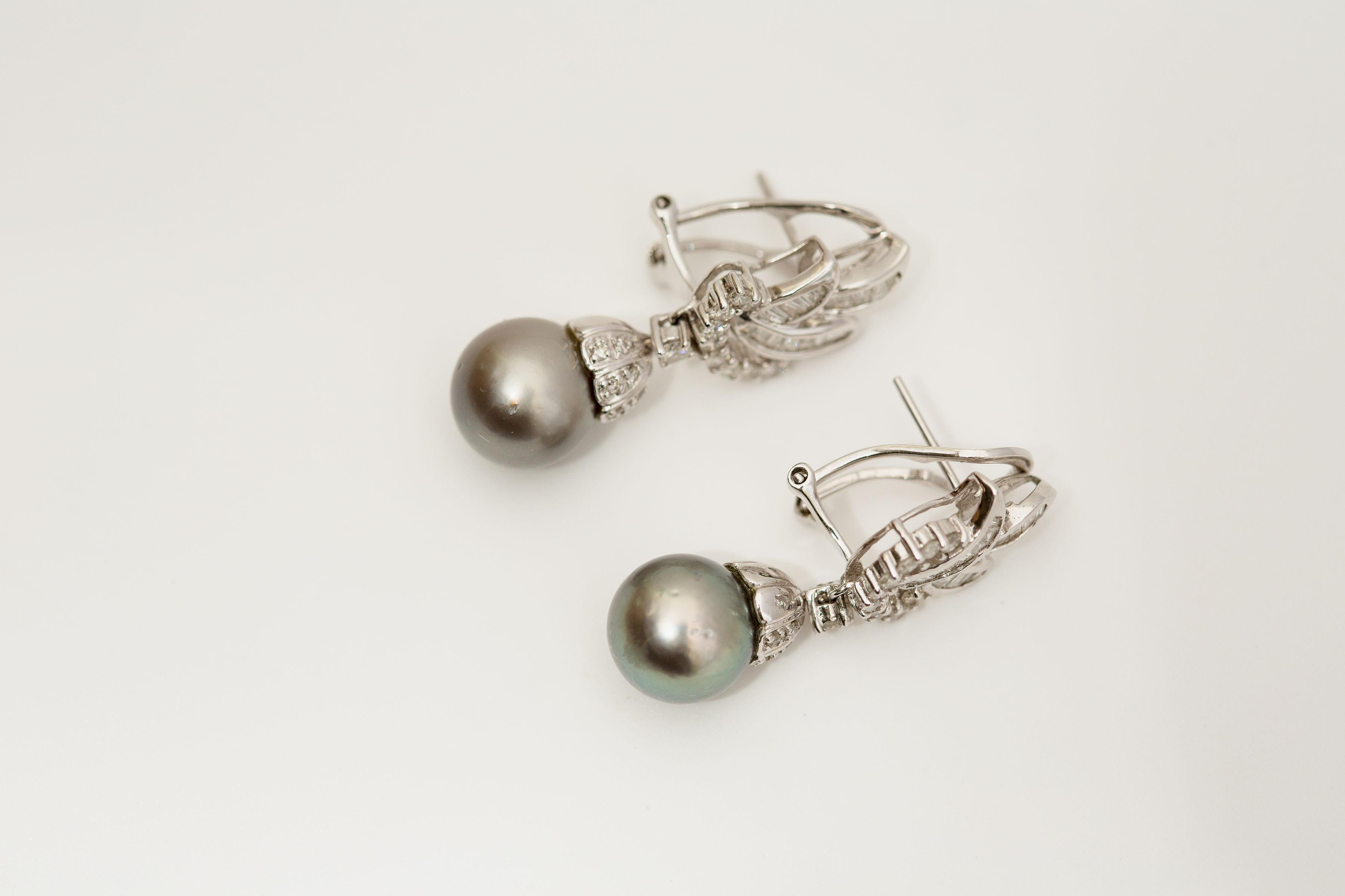 Material: oro Blanco 18k
Gema: Diamante 1.25 cttw
Perla de Tahití 10,6 mm
Peso: 11.2 gramos

Preciosos pendientes clásicos que combinan el brillo infinito de los diamantes con el lustre de las perlas oscuras de Tahití. Estos pendientes pueden