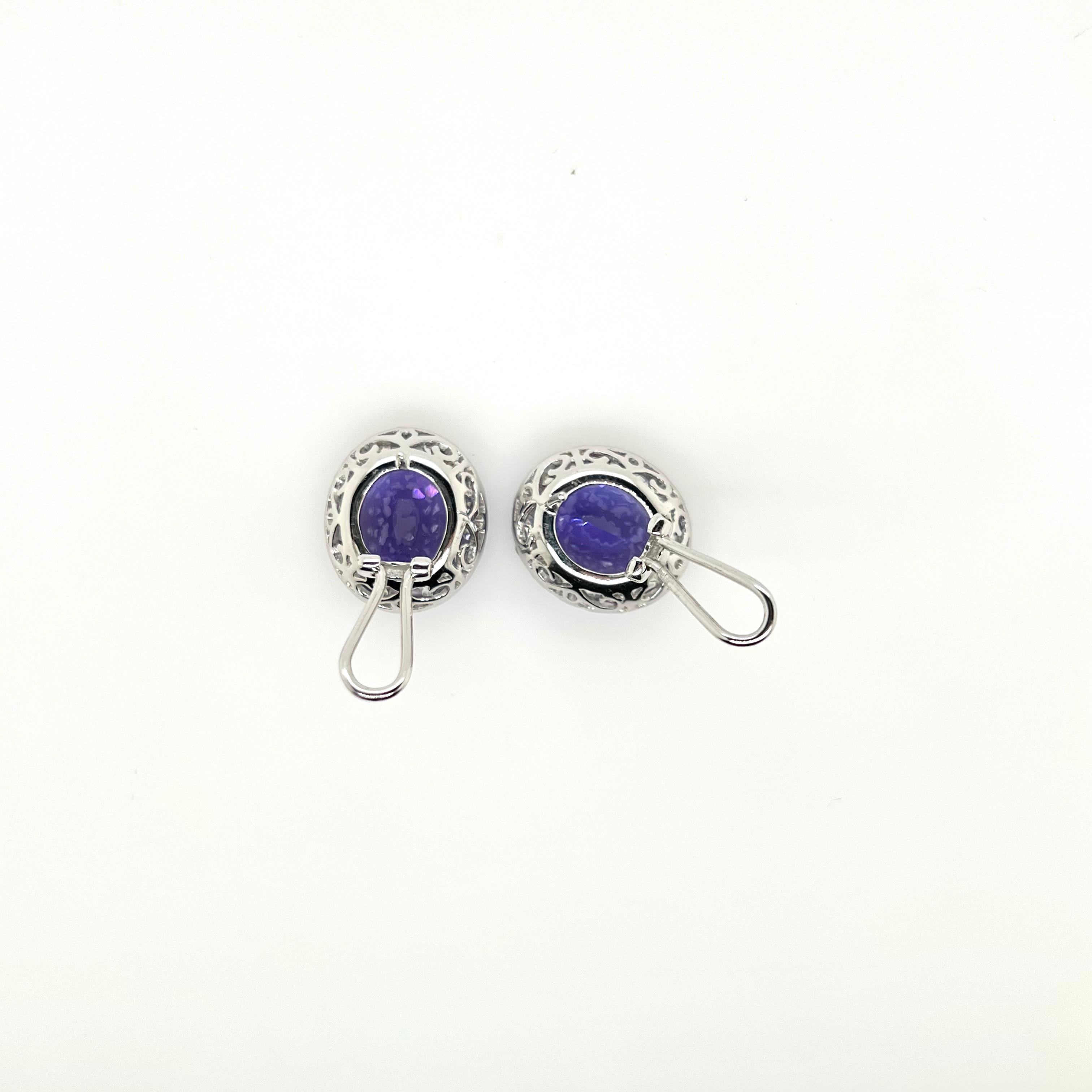 The epitome of a classic earring design!   This stunning pair of tanzanites are set in a handmade setting with round brilliant diamonds around the peripheral to give the iconic earring style!  The vibrant purple hue in the tanzanite glisten against
