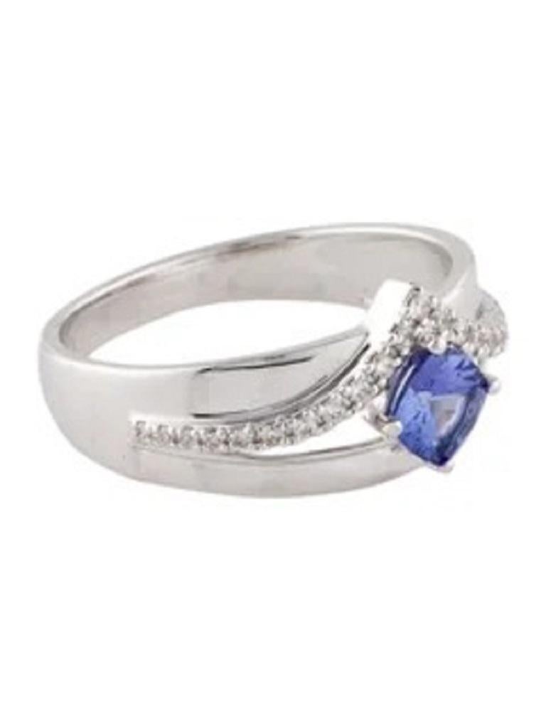 Elevate your ensemble with our exquisite 18K Tanzanite & Diamond Cocktail Ring. Crafted from luxurious 18K white gold, this ring features a stunning 0.60-carat cushion modified brilliant tanzanite, exuding a mesmerizing violet hue. Surrounding the