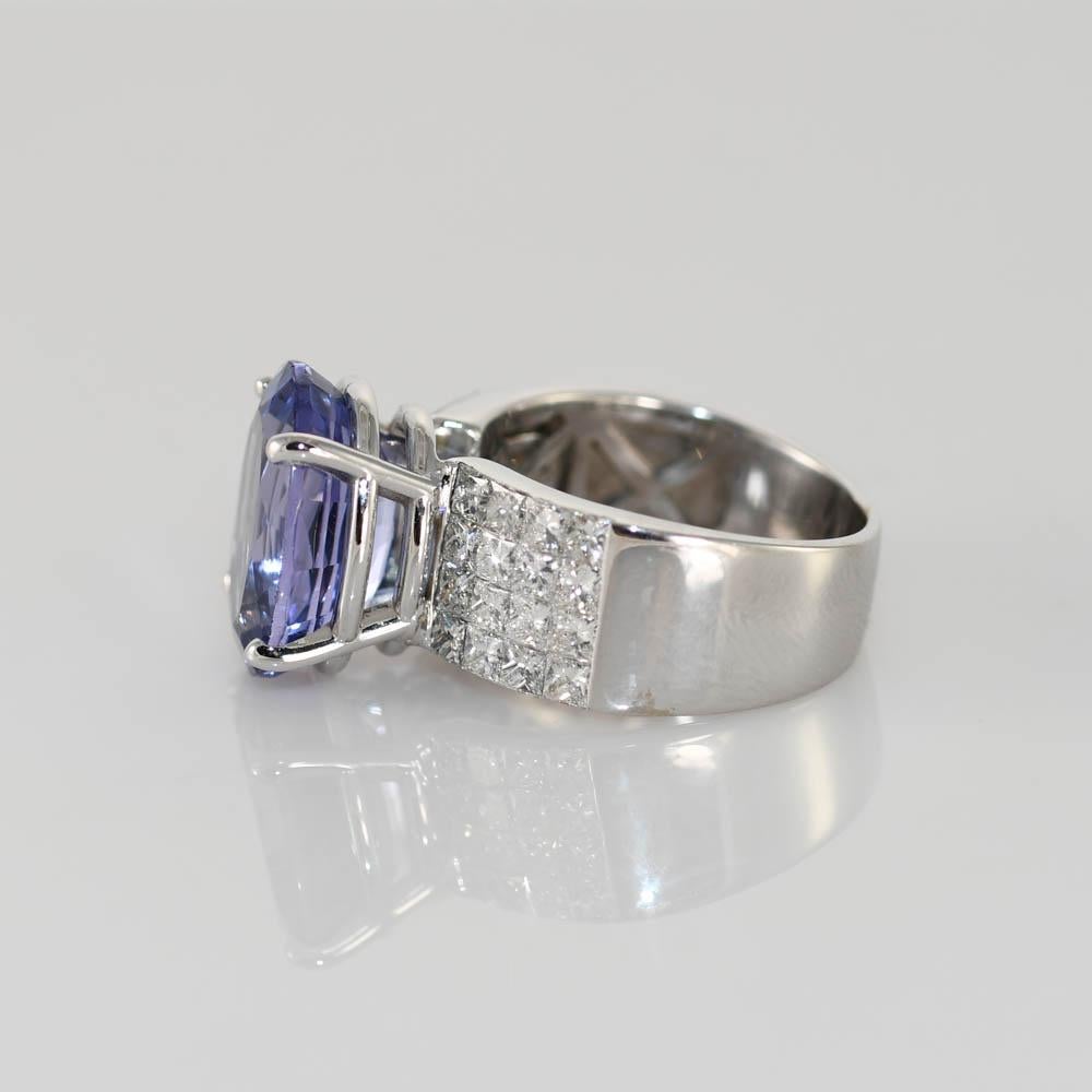 Tanzanite and diamond ring in 18k white gold setting.
Stamped, 18k, 750, and weighs 10.3 grams.
The oval-shaped Tanzanite weighs 7.82 carats, pale violet-blue color.
On the sides are princess cut diamonds, 1.50 total carats, G color, VS