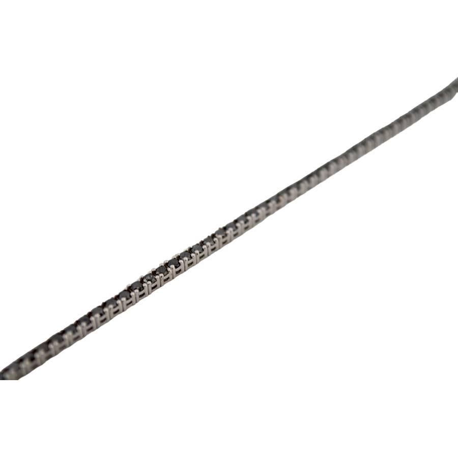 Mystérieux, moderne et irrésistiblement élégant, ce bracelet tennis en or blanc 18 carats est l'expression raffinée d'un luxe audacieux. Avec 77 diamants noirs naturels d'un poids total de 3,5 carats, chaque pierre est taillée en brillant pour