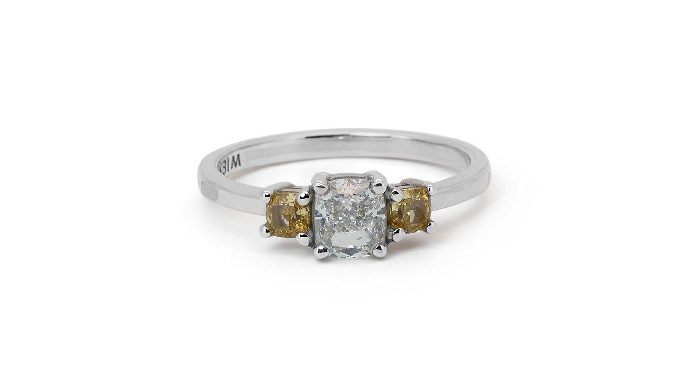 An elegant three-stone ring with a dazzling 0.75 carat cushion modified natural diamond. It has 0.36 carat of side diamonds which add more to its elegance. The jewelry is made of 18K White Gold with a high quality polish. It comes with IGI